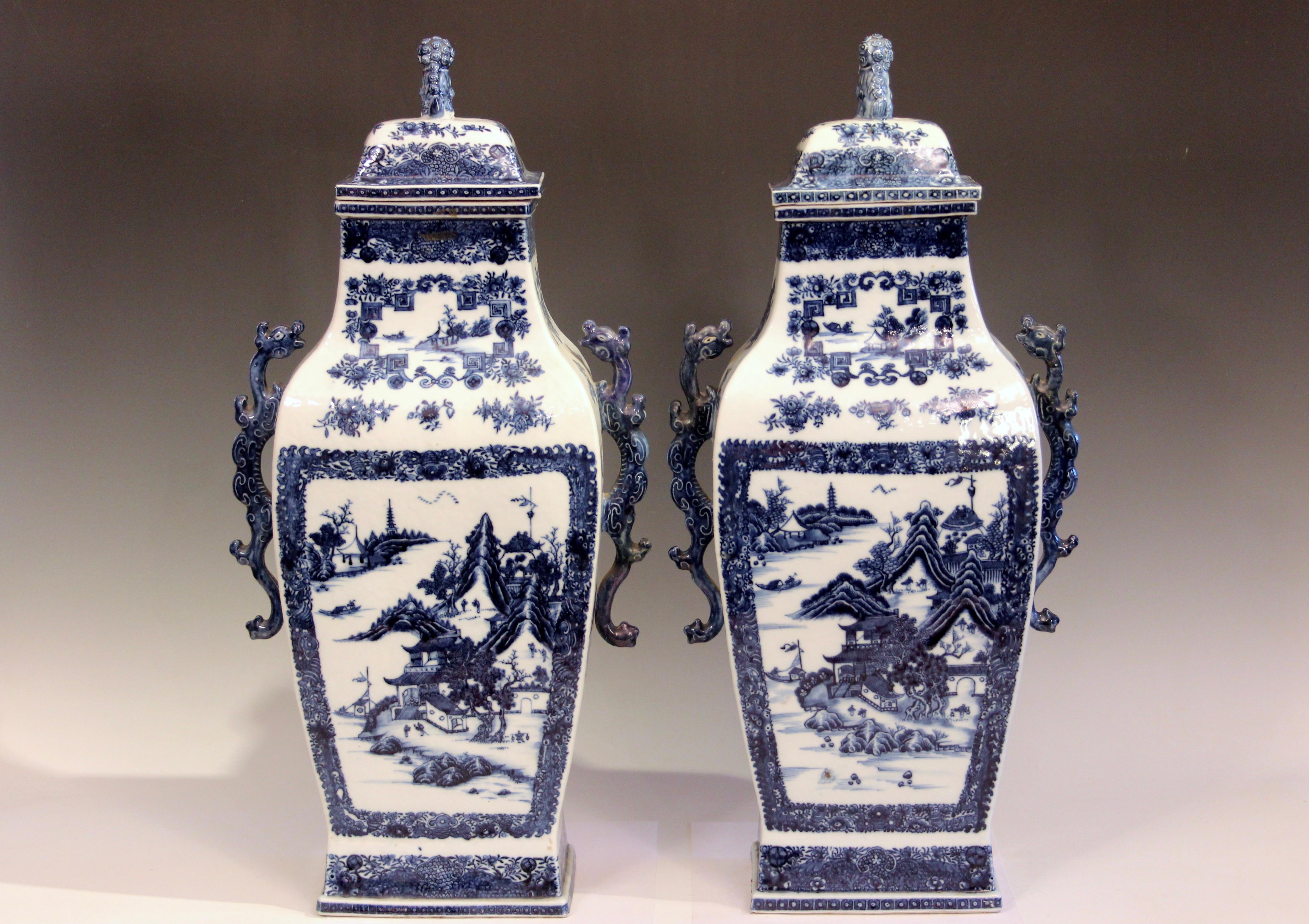 Pair of imposing antique Chinese export blue and white porcelain rectangular form urns with covers. Nanking pattern scenes in stunning detail and superb color. These date from the late 18th century, circa 1790's. Fanciful dragon form handles. These