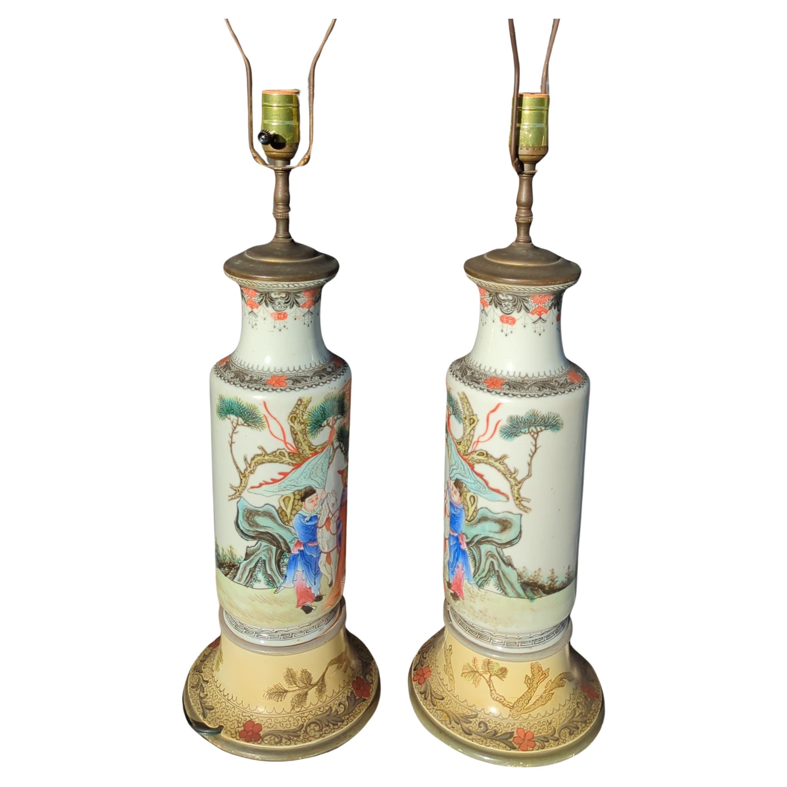 A matching mirror pair of antique Chinese early 20th century famille rose figural rouleau vase turned into lamps. The finely painted decorations depict a scene of a general looking up into the heaven, to gaze up on a group of floating fairies