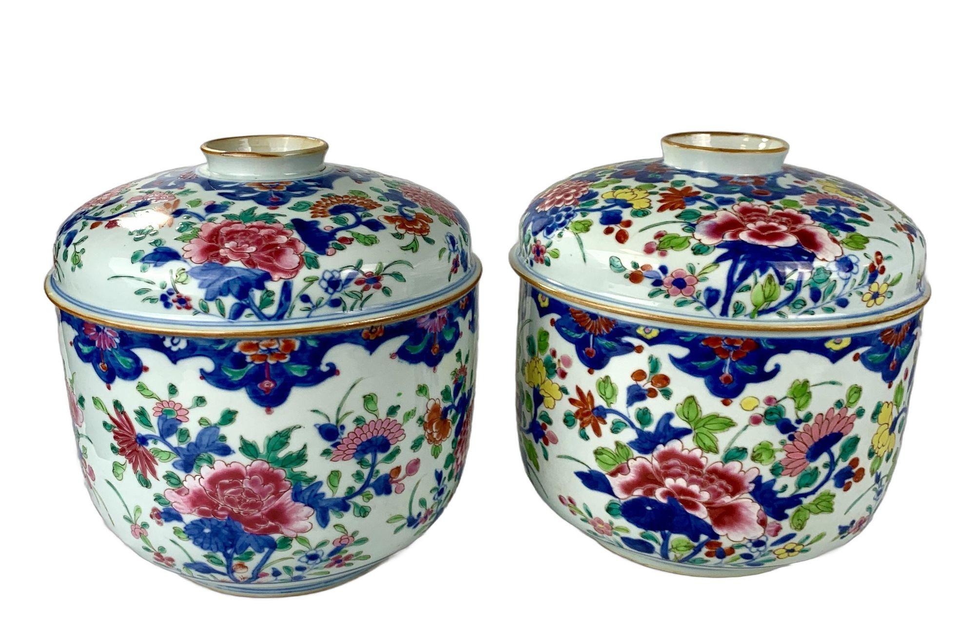 This exceptional pair of 18th-century Chinese porcelain jars is hand-painted in vibrant famille rose enamels with blooming peonies, chrysanthemums, and plum blossoms in brilliant shades of pink, blue, orange, green, yellow, and red. 
The floral
