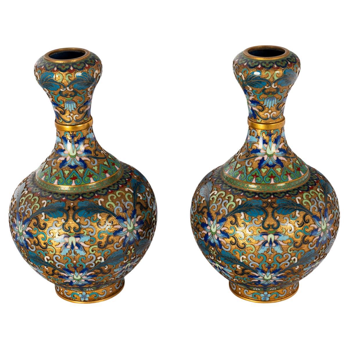 A good pair of late Qing early Republic period 'garlic' neck champlevé & cloisonné vases, circa 1910.
Both vases are lavishly decorated with both cloisonné & champlevé enameled decoration, in a 'thousand flowers' pattern.   
The garlic bulb shaped