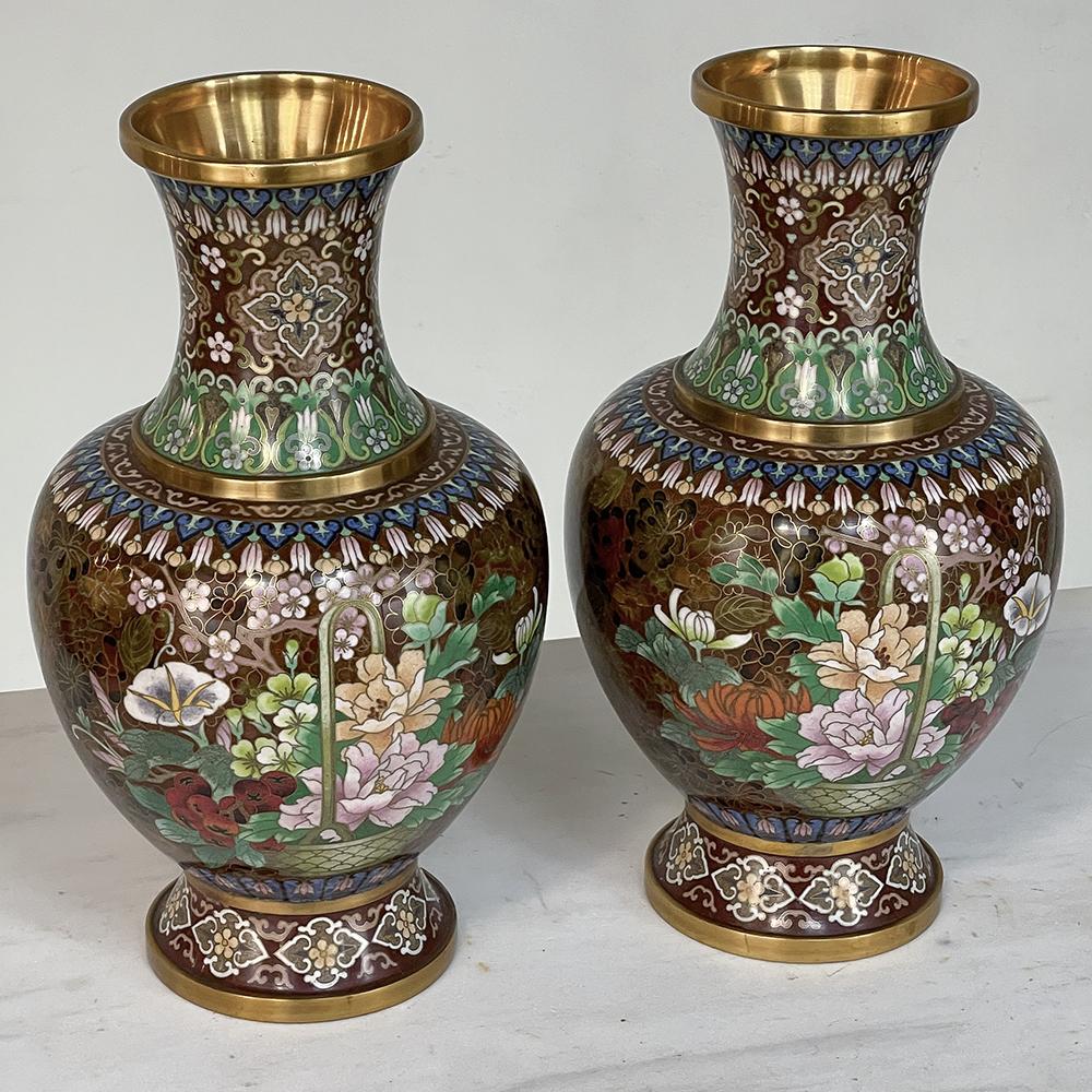 Cette paire de vases anciens Cloissone est un exemple extraordinaire de la race, affichant une riche coloration bien préservée et présentant un thème de conception de grand format célébrant la beauté naturelle des fleurs. Décoré en rond, le fil de
