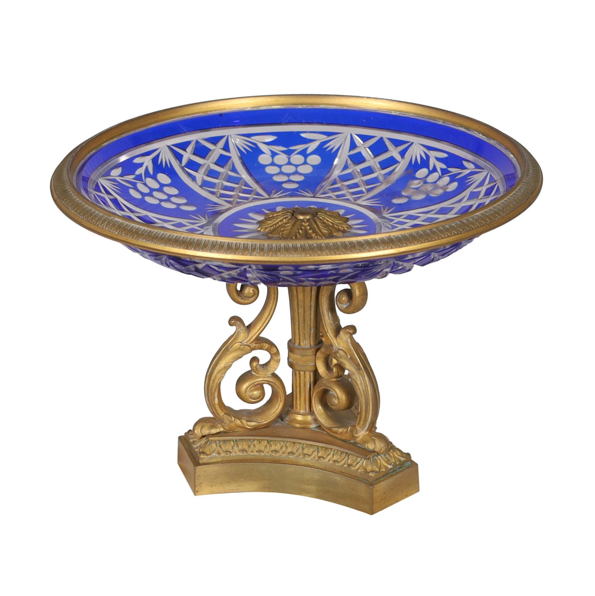 Our pair of antique (late 19th century) compotes in the neoclassical style with gilt bronze frame and cobalt blue flashed and clear glass bowls have engraved designs of latticework and stylized grape bunches.   Each in good condition.
