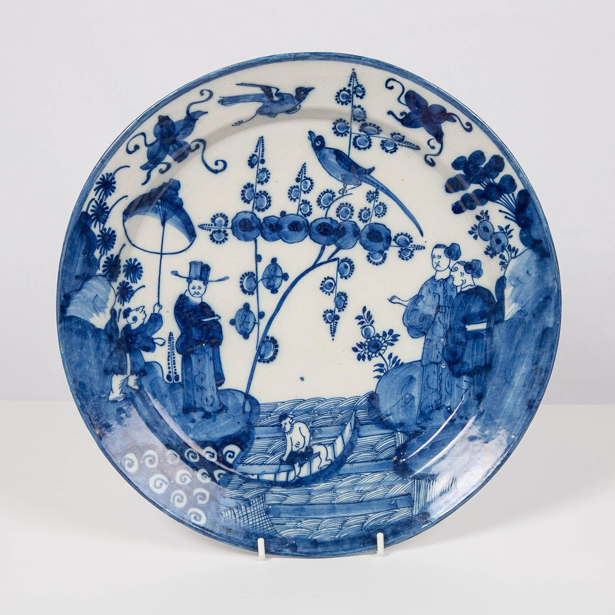 We are proud to offer this pair of large and particularly decorative delft chargers hand painted in cobalt blue and white. The design is distinctive in its decoration which features a chinoiserie scene covering the entire dish. This borderless