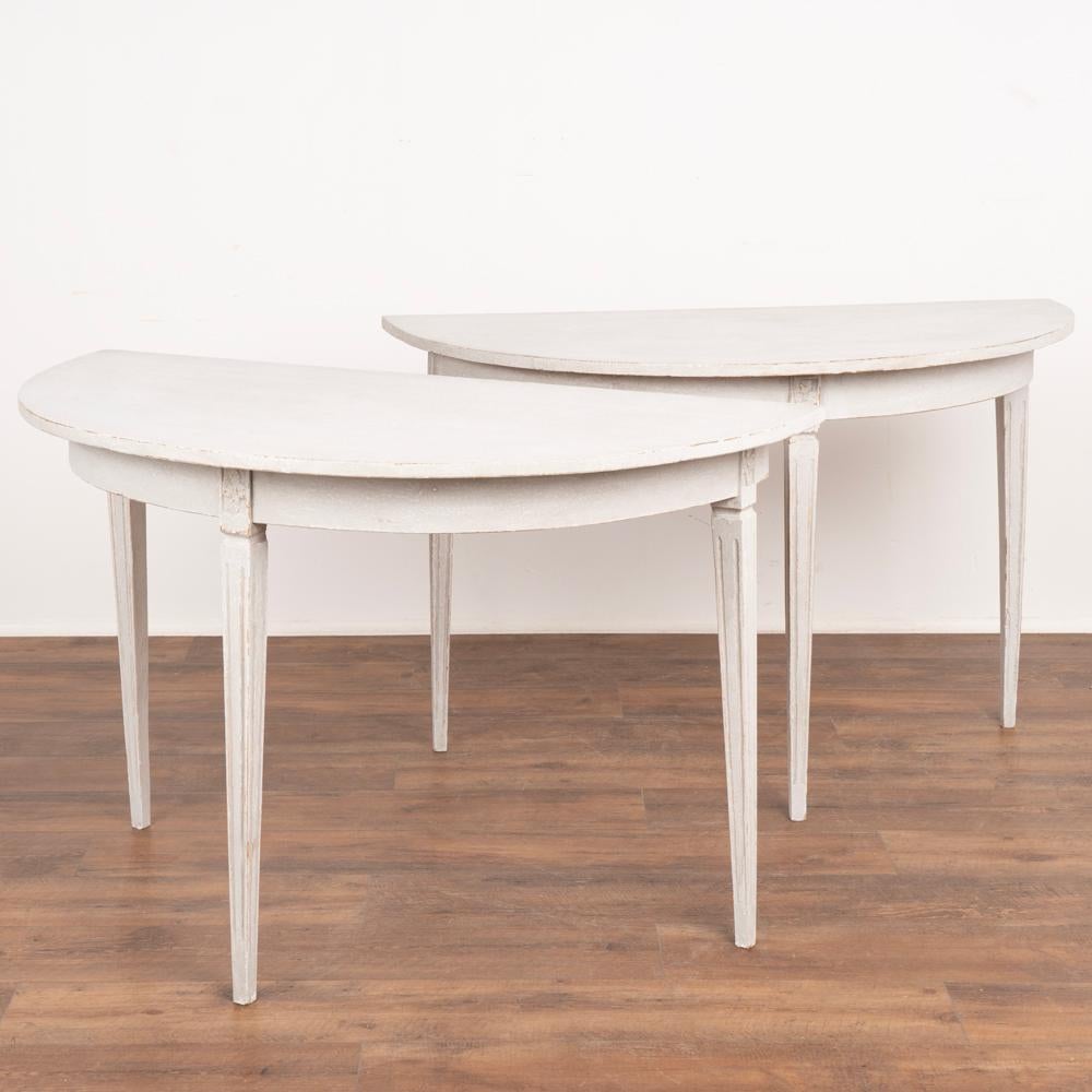 Pair, Swedish gray painted demil lune tables with tapered fluted legs.
Newer professionally painted in textured layers of gray and white.
Restored, strong and stable. Any age related cracks, scratches or wear are a reflection of generations of use