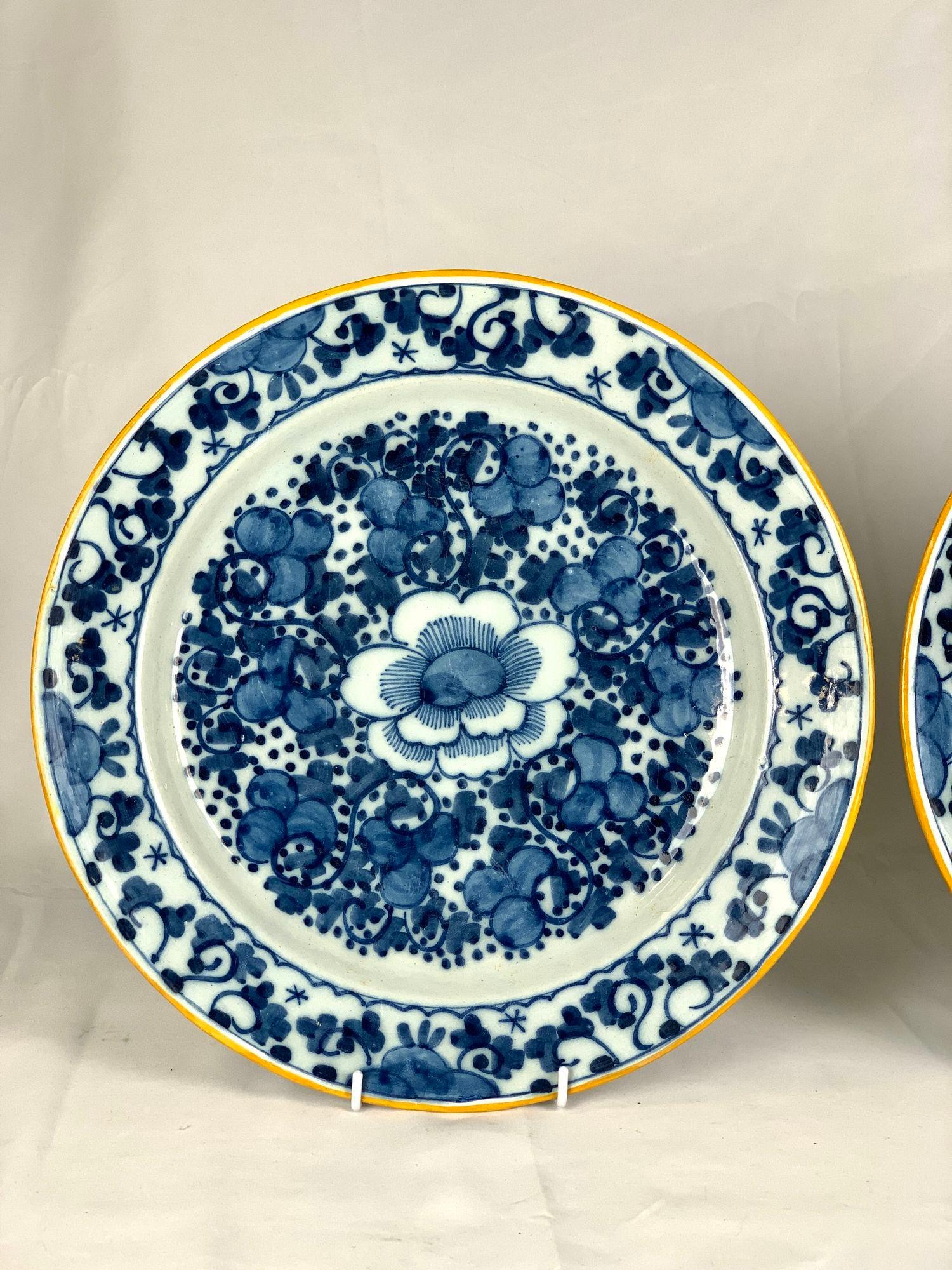 This pair of blue and white Dutch Delft chargers was made in the Netherlands circa 1780.
They feature a vibrant and beautiful design with a large flower at the center, surrounded by leaves and swirling vines.
The border is decorated with similar