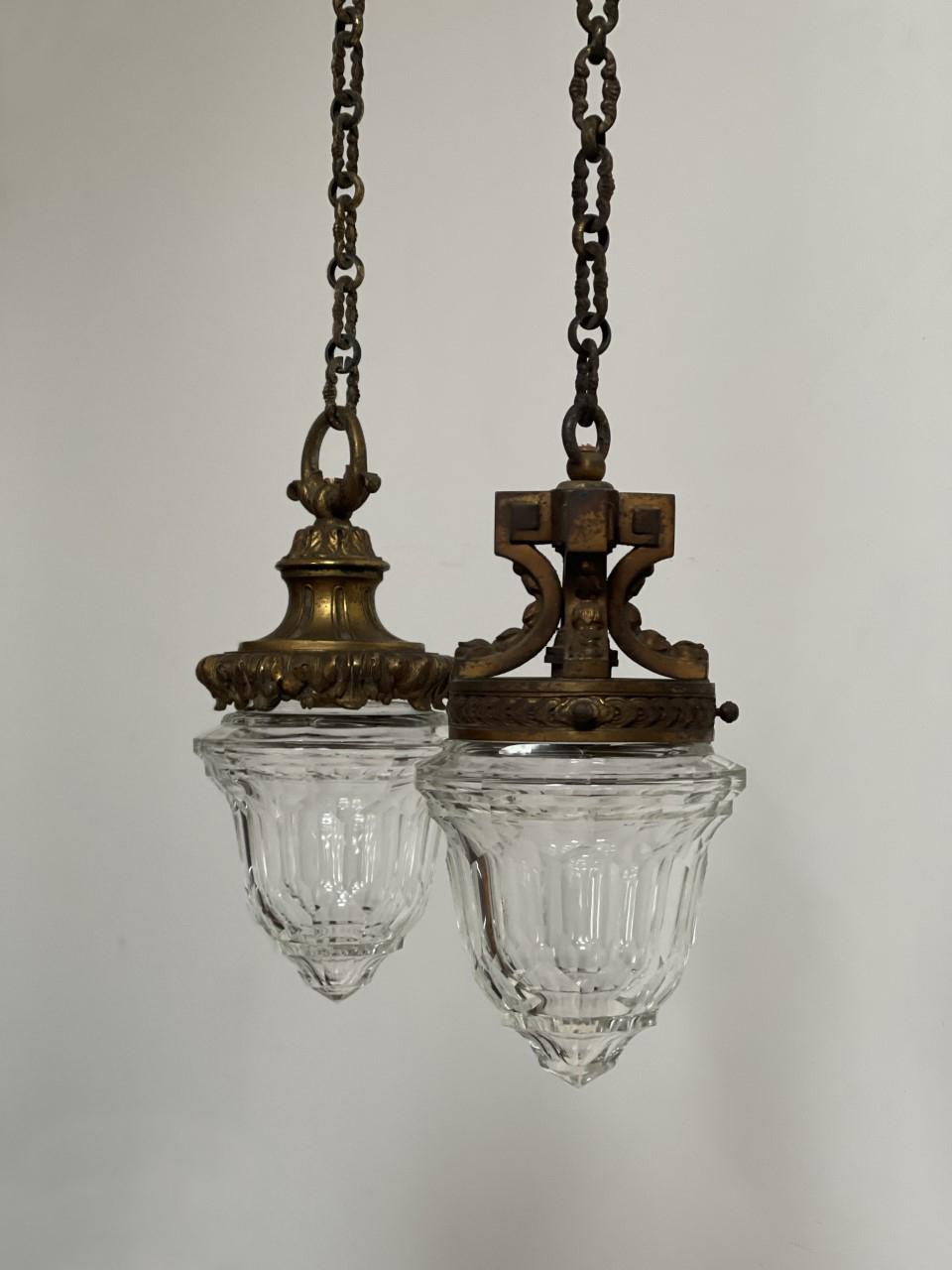 - A wonderful pair of antique cut glass pendants with original aged brass galleries, chain and ceiling roses, English circa 1910.
- The cut glass shades are identical across each of the designs, remarkable condition and unusual in form, they work