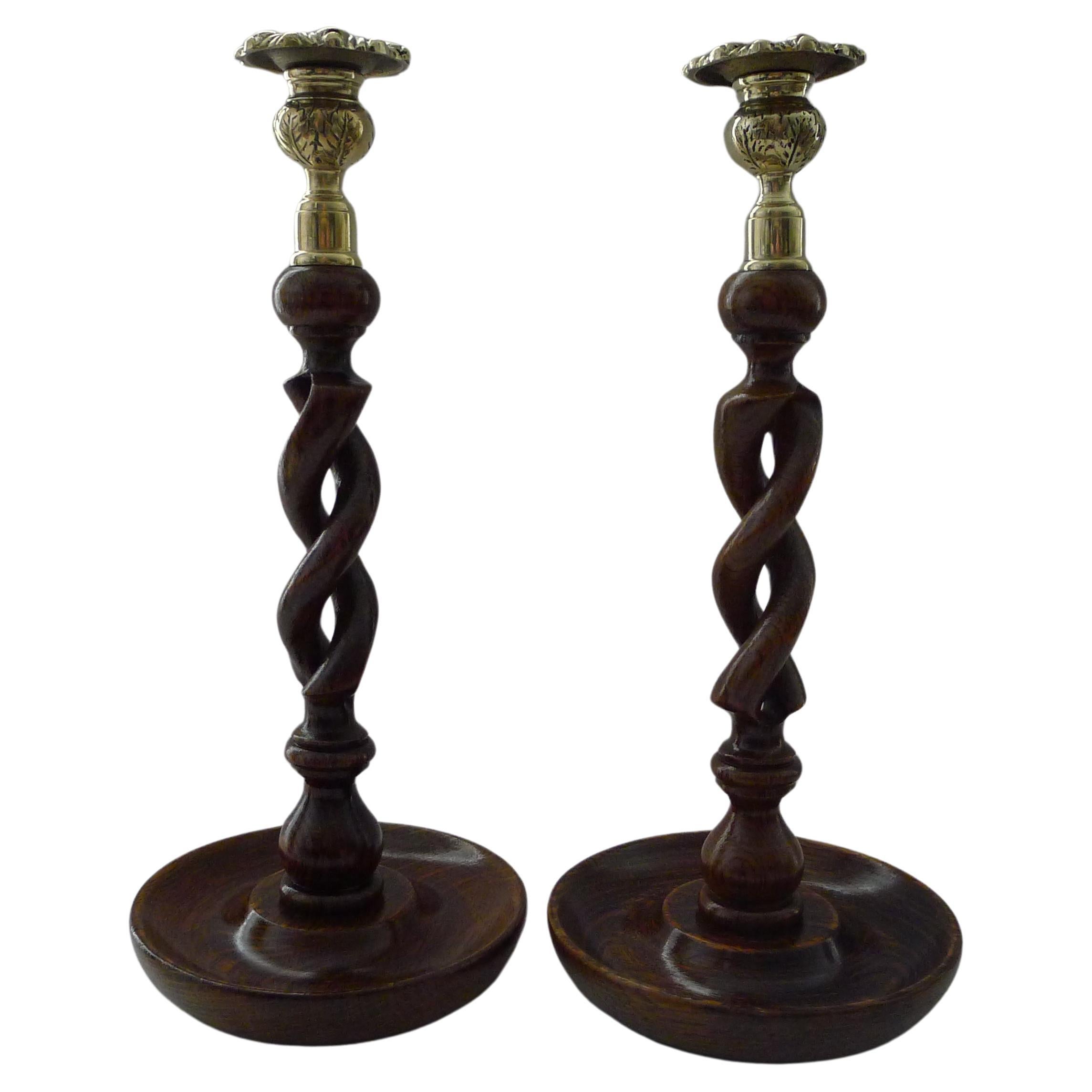 A wonderful pair of wooden candlesticks, always a winning combination, polished Oak and brass.

Not to be confused with a simple pair of twists, these are the highly sought-after 