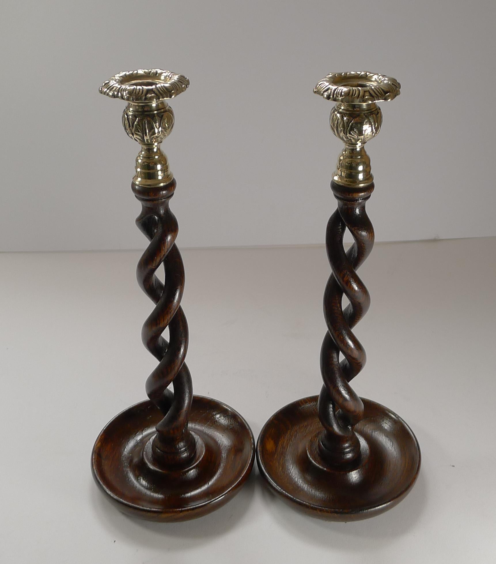 A handsome pair of antique oak candlesticks, and with much skill were lovingly carved, with an open barley twist design.

The tops have decorative brass tops, a winning combination with the rich coloured Oak.

A good size measuring 12 3/4