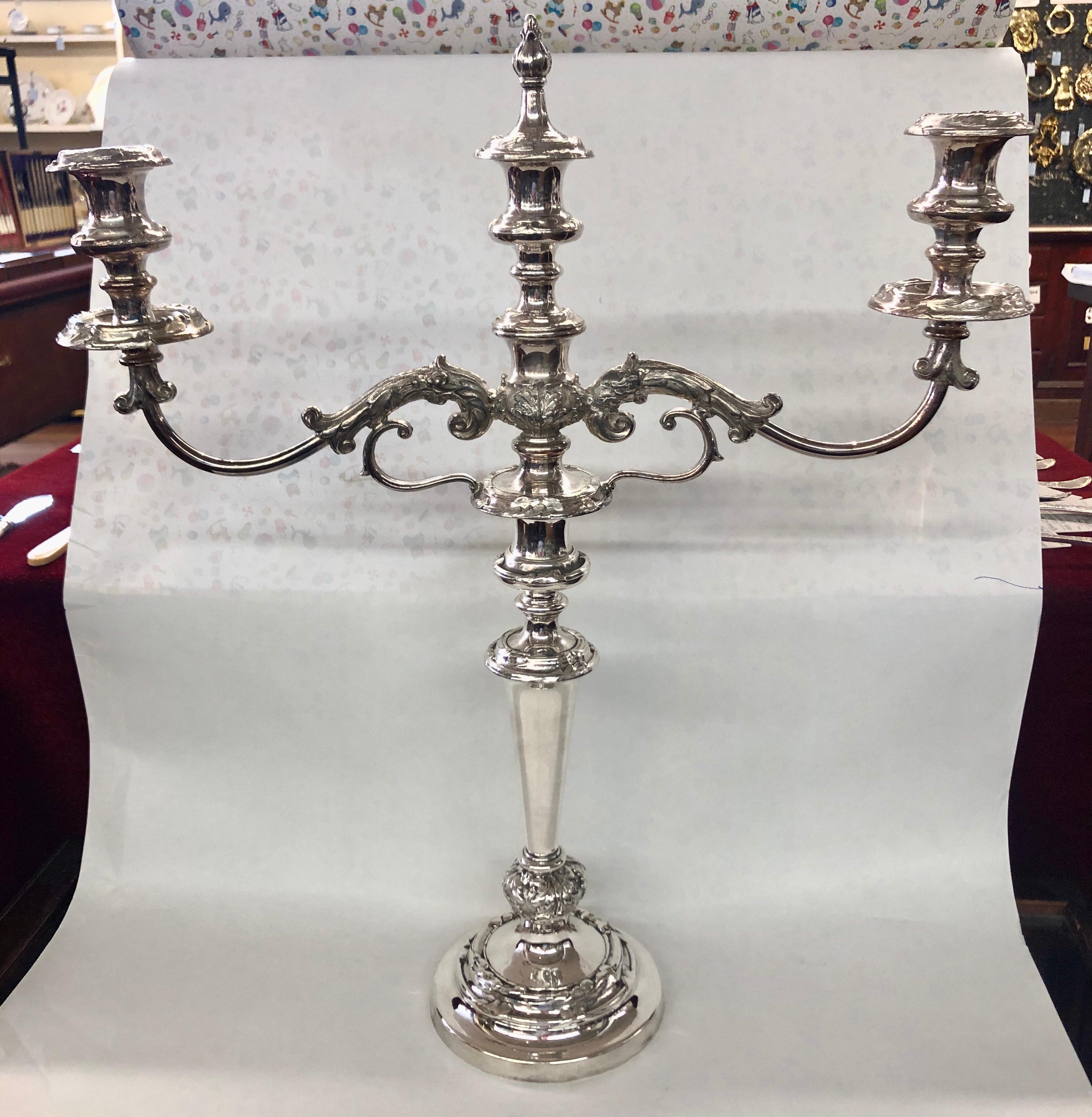 Pair of exceptional quality antique English “Old Sheffield Plate” three-light rococo style candelabra with central snuffer flame finial which is removable to reveal a center candle. The rococo bobeches are original and removable and the candelabra