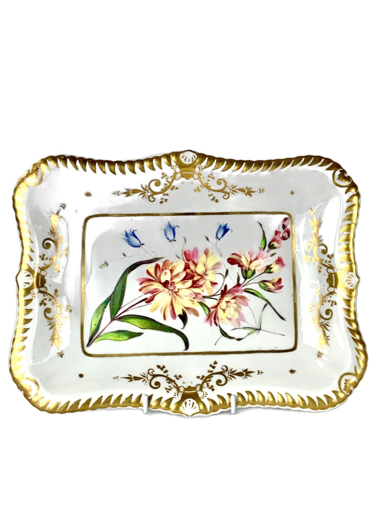 Cette magnifique paire de plats anciens en porcelaine anglaise a été fabriquée par Chamberlains Worcester vers 1830.
Chaque plat a une forme rectangulaire gracieuse avec des bords légèrement festonnés et un rebord finement doré.
Au centre de chacune