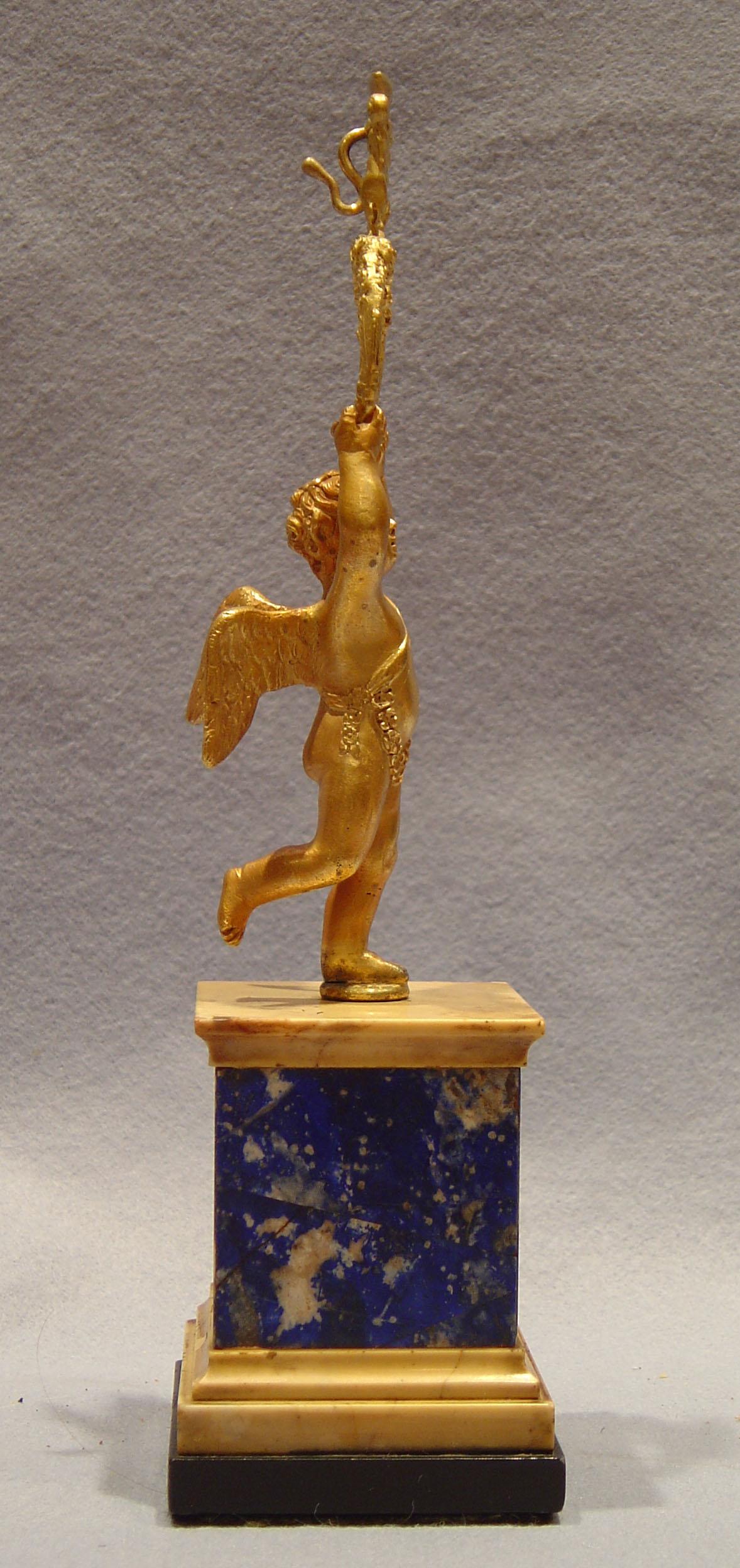 Superb near pair of Russian or English early 19th century watch or portrait holders. In the finest quality ormolu set on square socles. The bases of square form in black and Sienna marble set with lapis lazuli. The figure is of a winged cupid with