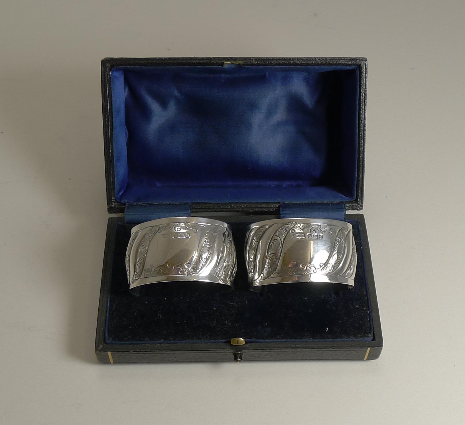 A wonderful pair of late Victorian napkin rings made from English sterling silver with embossed and engraved decoration, each with a vacant cartouche to the front.

Both protected by their original presentation case, each is fully hallmarked for