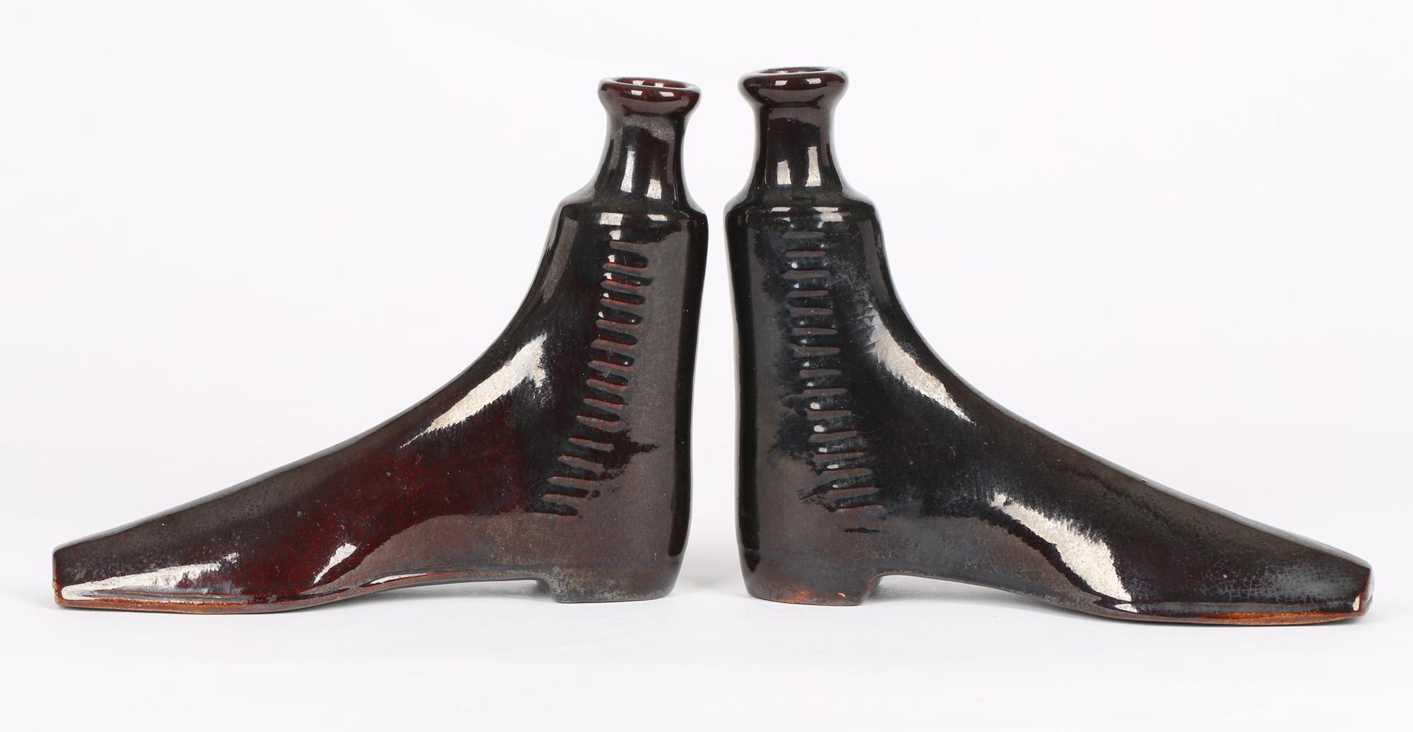 A fine pair of antique English treacle glazed pottery spirit flasks modeled as ankle boots applied with laces to the side and probably dating from around the mid 19th century. The flasks are hollow potted with raised filler/pourer which would
