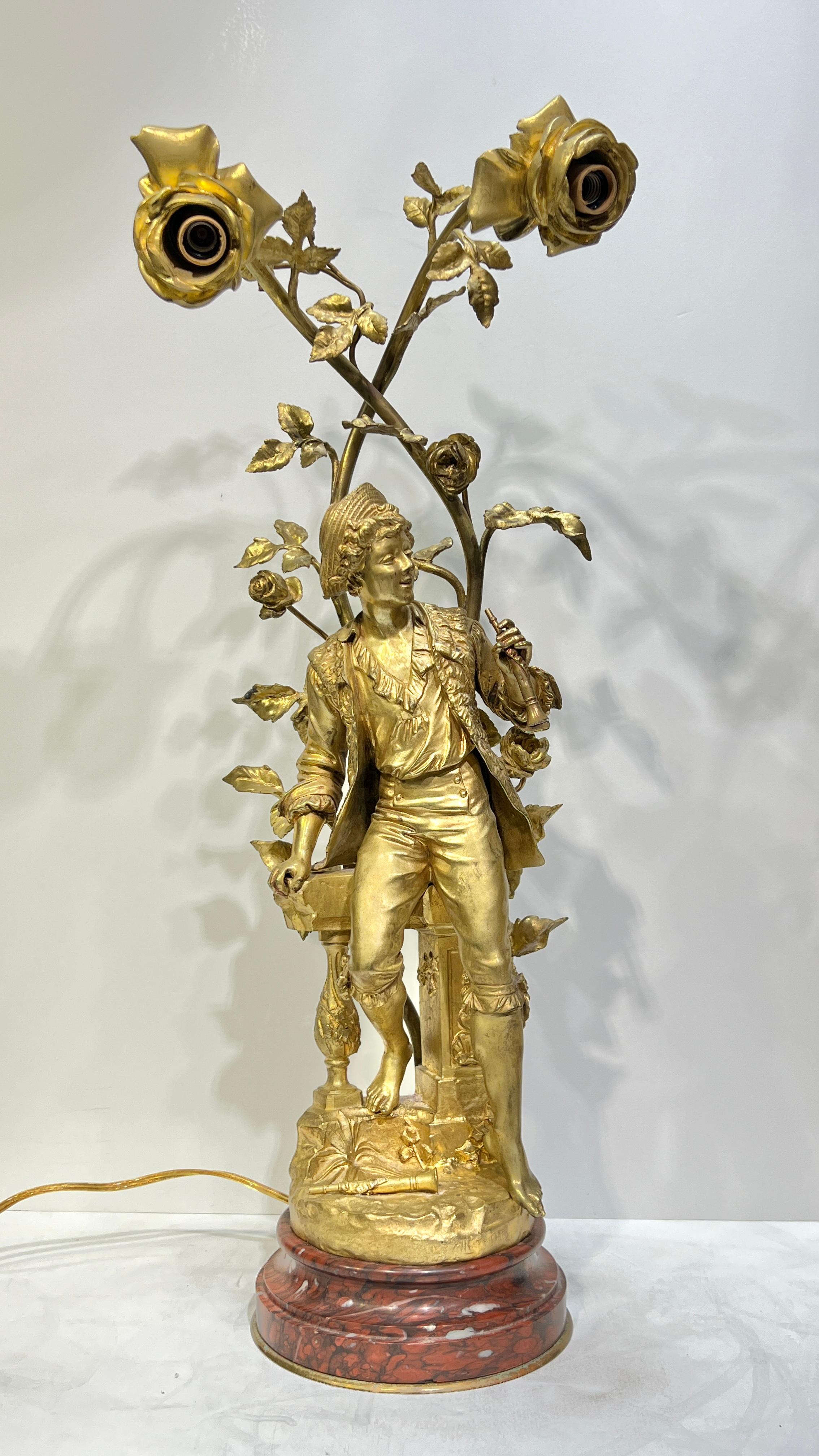  pair of figural gilt bronze candelabra lamps depicting joyful young man and woman with rose flowers housing candelabra size sockets, and mounted on circular rouge marble pedestals.  With modern wiring, cord and plug, ready to enjoy.  The largest 25