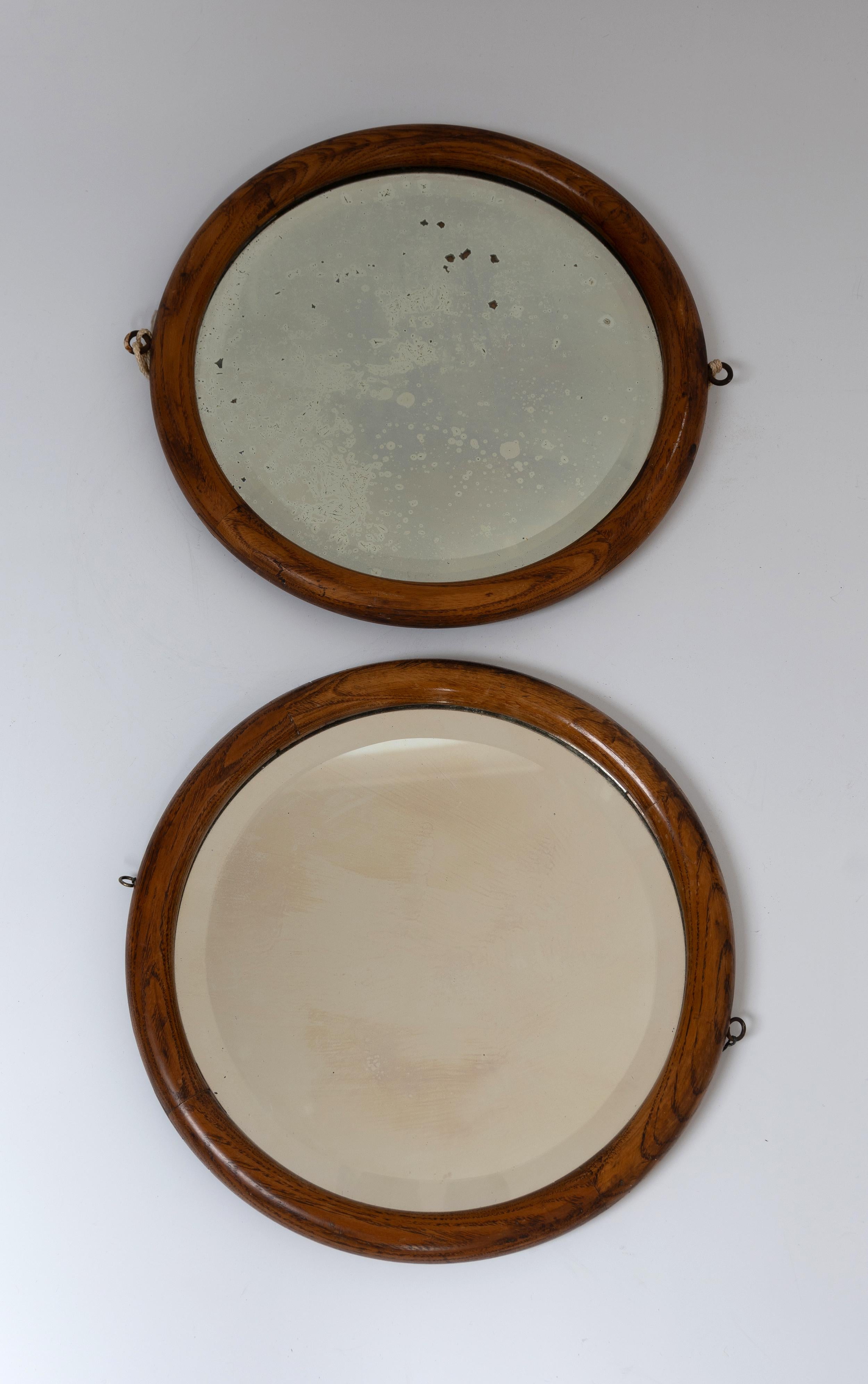 Paire de miroirs hublots ronds français anciens du 19ème siècle
Encadrement en noyer avec patine attrayante sur le miroir 
(Un miroir peut avoir été remplacé précédemment).
En bon état correspondant à l'âge, avec des signes de vieillissement (se