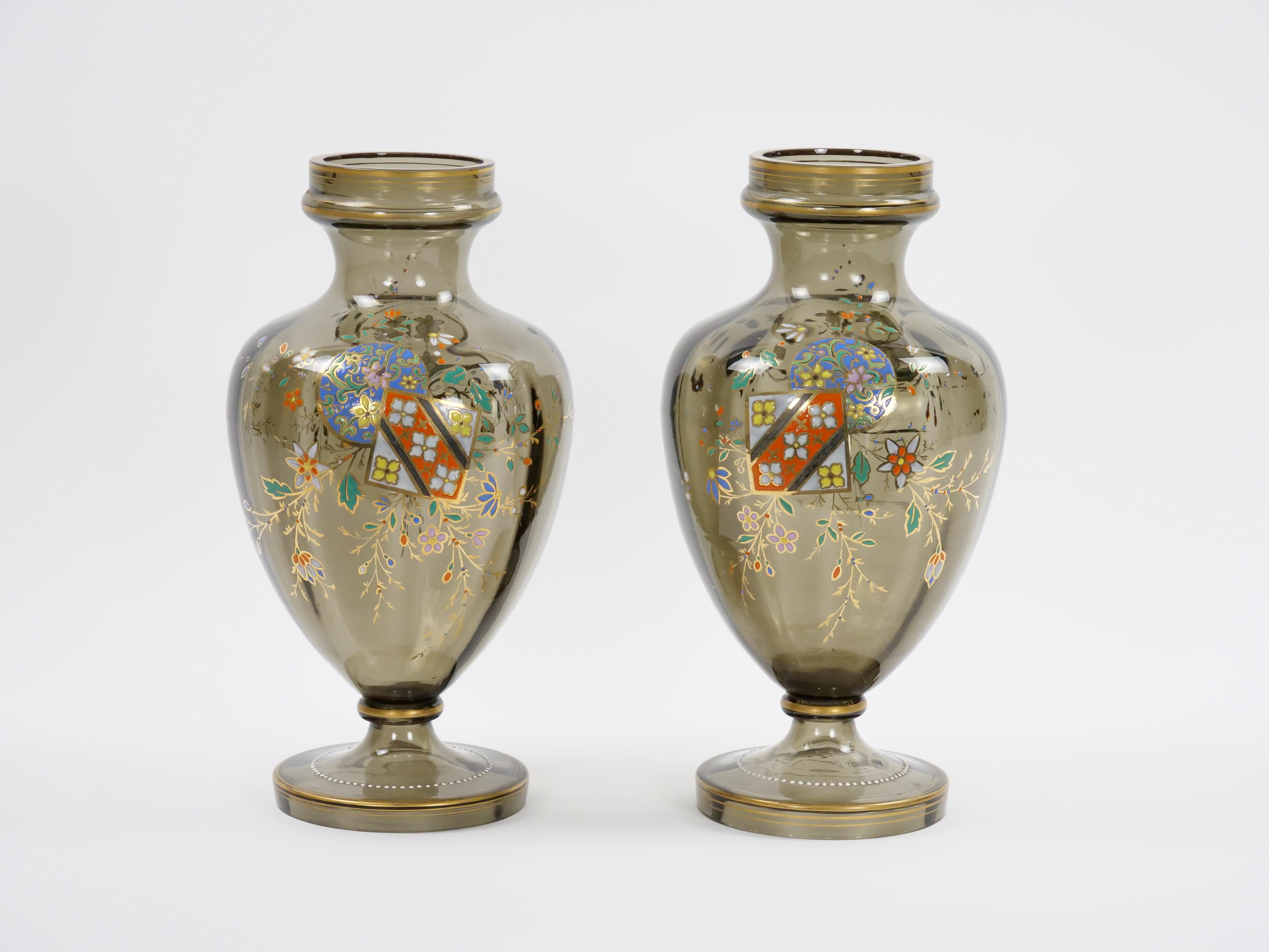 Experience the allure of the past with this captivating pair of antique French hand-gilt and decorated enameled gray-tinted glass vases. These vases are not just decorative pieces; they are portals to a bygone era of opulence and artistic finesse.