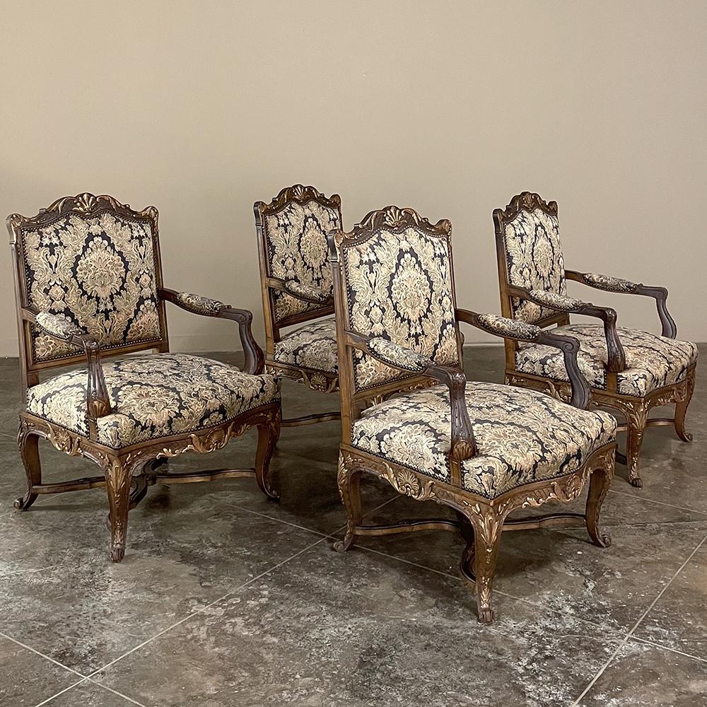 Pair antique French Louis XIV hand-carved armchairs recall the glory years of the Sun King, and feature timeless styling inspired by classicism with Baroque flair. Each chair has been recently upholstered in a high quality print fabric for year