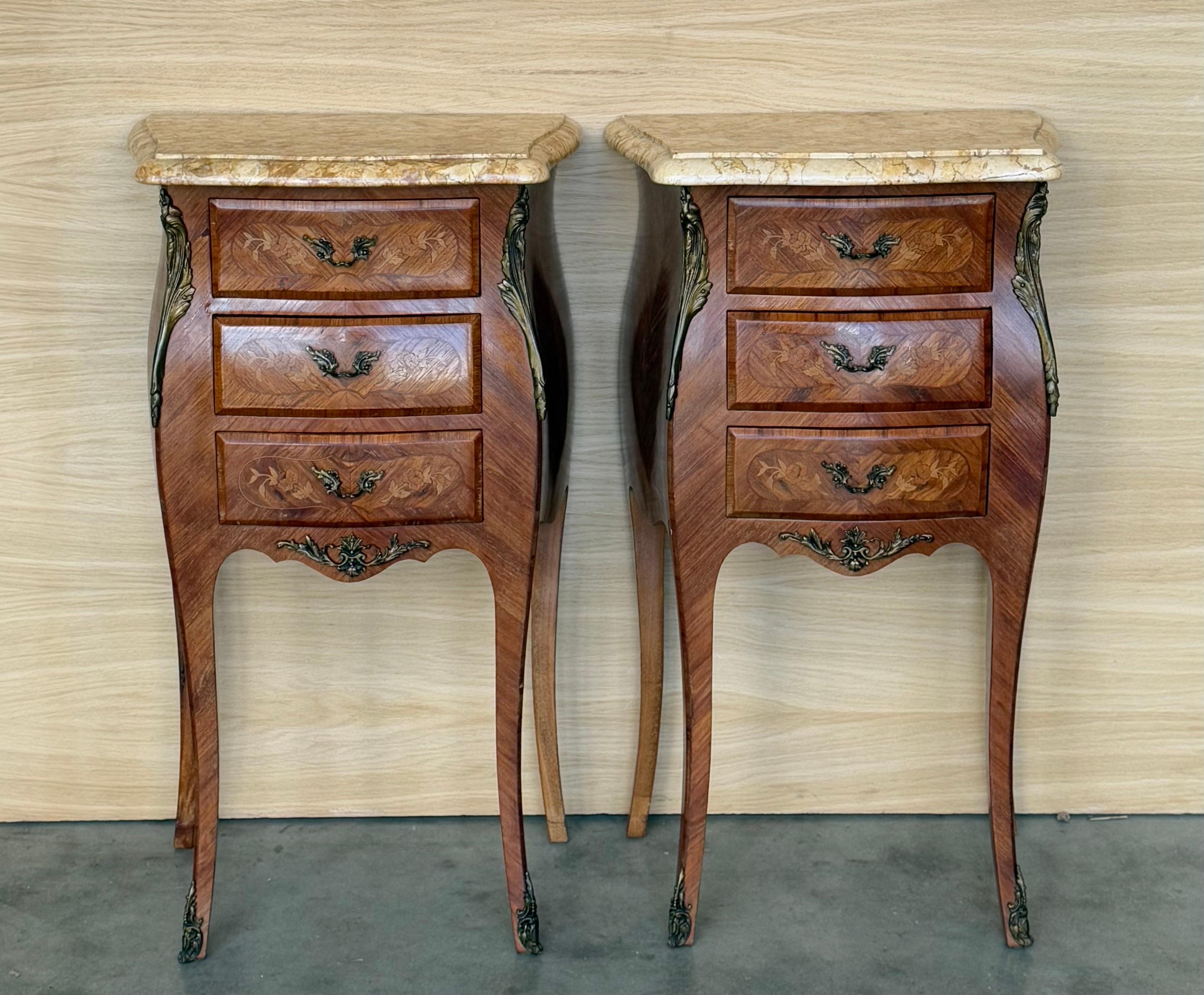 Pair Antique French Louis XV Marquetry marble top nightstands offer a lot of style in diminutive packages! The subtle contours and scroll forms are evident in the cornerposts and legs, supporting serpentine sides and a bowed front facade for a