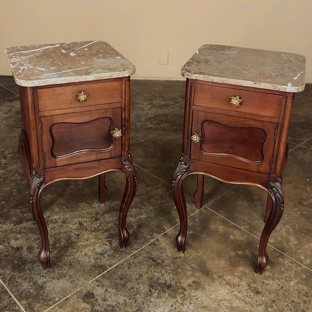 Pair antique French Louis XV walnut marble top nightstands were rendered from sumptuous indigenous walnut with tailored lines for the casework contrasting the boldly scrolled and carved cabriole legs, four of which support each piece! Topped with