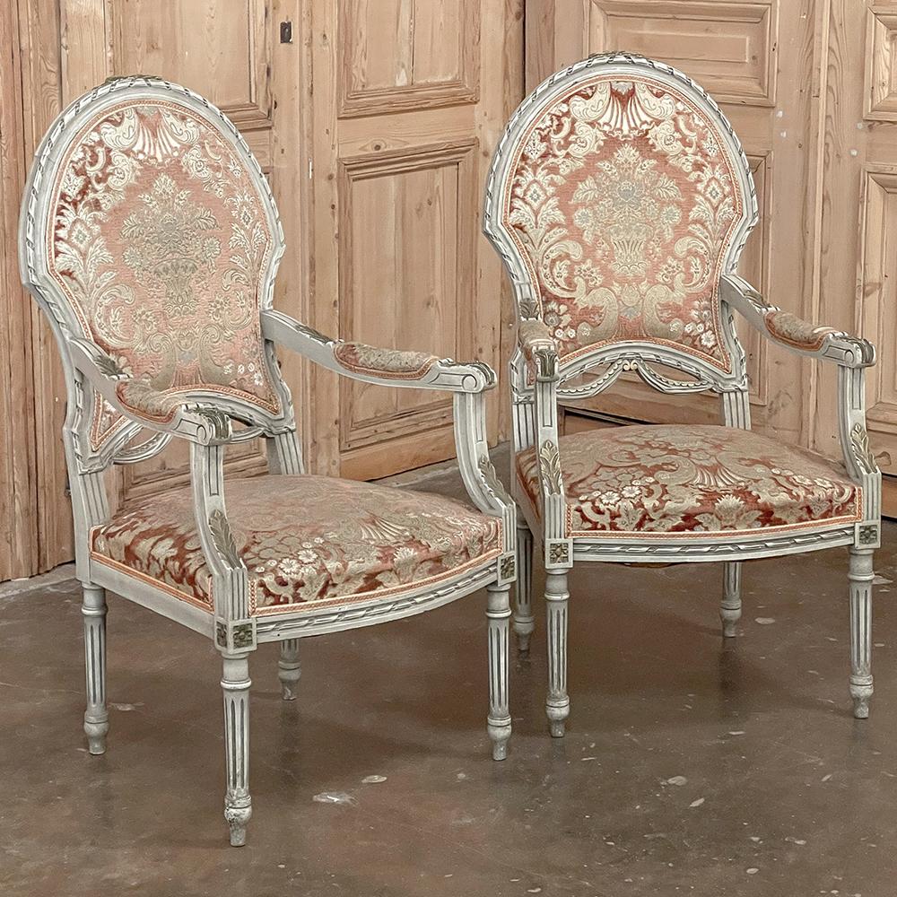 Pair antique French Louis XVI painted armchairs ~ fauteuils will make a classic addition to any decor! The ovoid shield shaped seat back and generous seat are framed in incredibly detailed carved fruitwood, styled with spiral ribbon, fabric swags