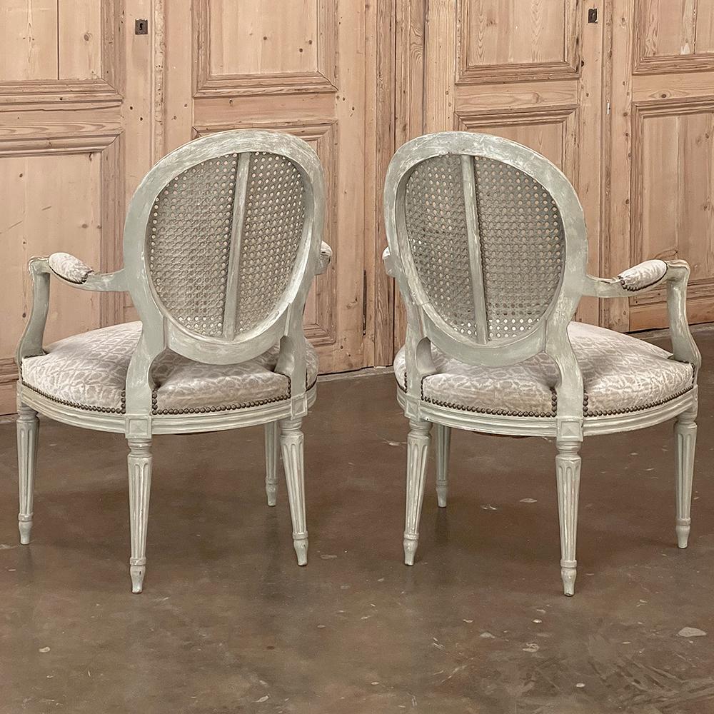 20ième siècle Paire de fauteuils français anciens peints de style Louis XVI avec canne et tissu en vente