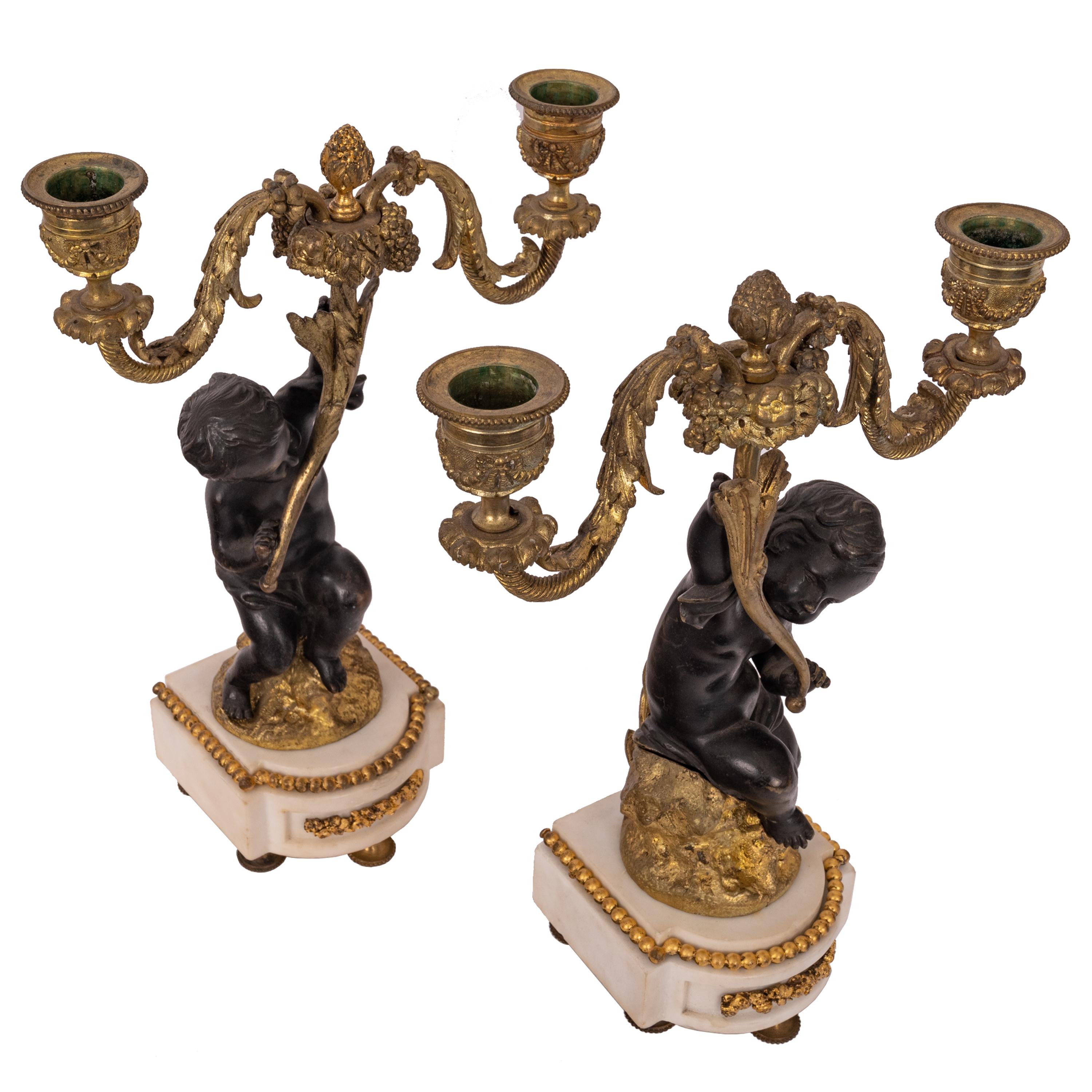 A very good pair of antique French Louis XVI bronze, parcel-gilt and marble putti candelabra, circa 1870.
Each candelabra having twin candle holders and each bobeche in gilt bronze with fruiting swags and fruiting acanthus finial to the center. Each