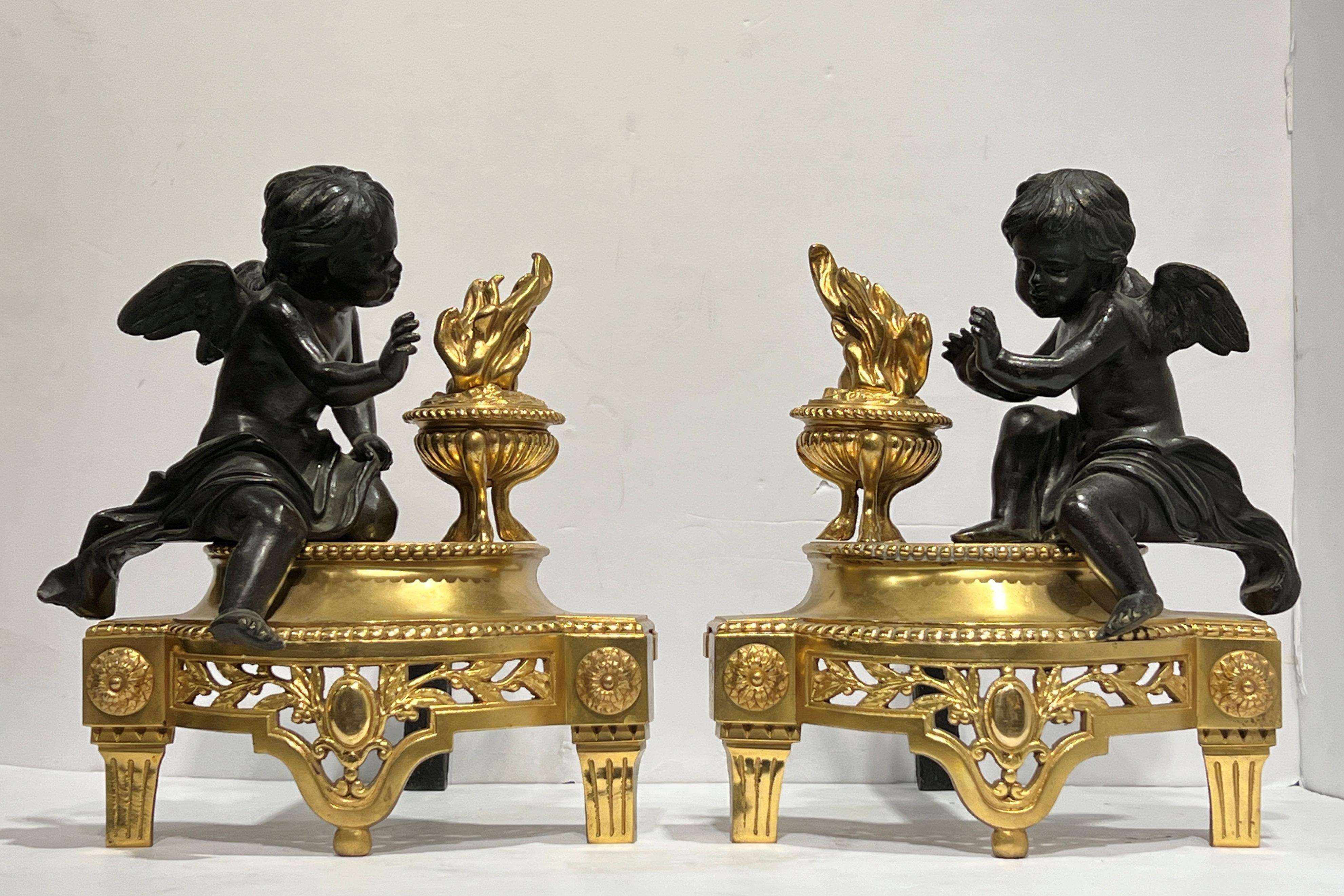 Coppia di androni (chenet) antichi (fine XIX-inizio XX secolo), finemente scolpiti e fusi in bronzo con superfici dorate e patinate, raffiguranti Cupido accanto a una torcia fiammeggiante.  11 1/2 per 10 x 13 pollici ciascuno.
