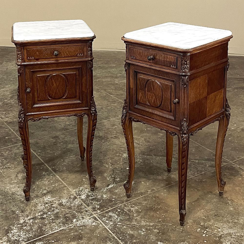 Pair Antique French Louis XVI walnut marble top nightstands exude luxurious style from every angle! Hand-crafted from select figured walnut, each features timeless neoclassical styling and hand-carved embellishment by truly talented artisans! Topped