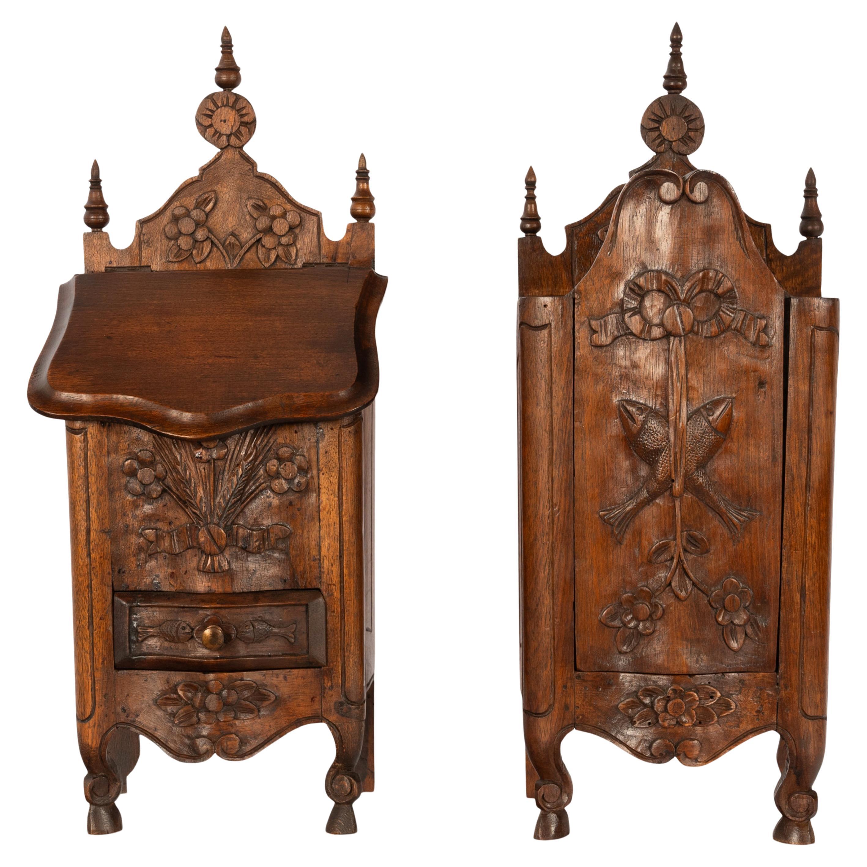 A very good pair of antique Louis XV French carved walnut Provincial Salt (Saliero) and flour (Fariniere) boxes, circa 1870.
Each box is finely carved & both boxes have three turned finials to the back and each central finial having a carved 'sun'