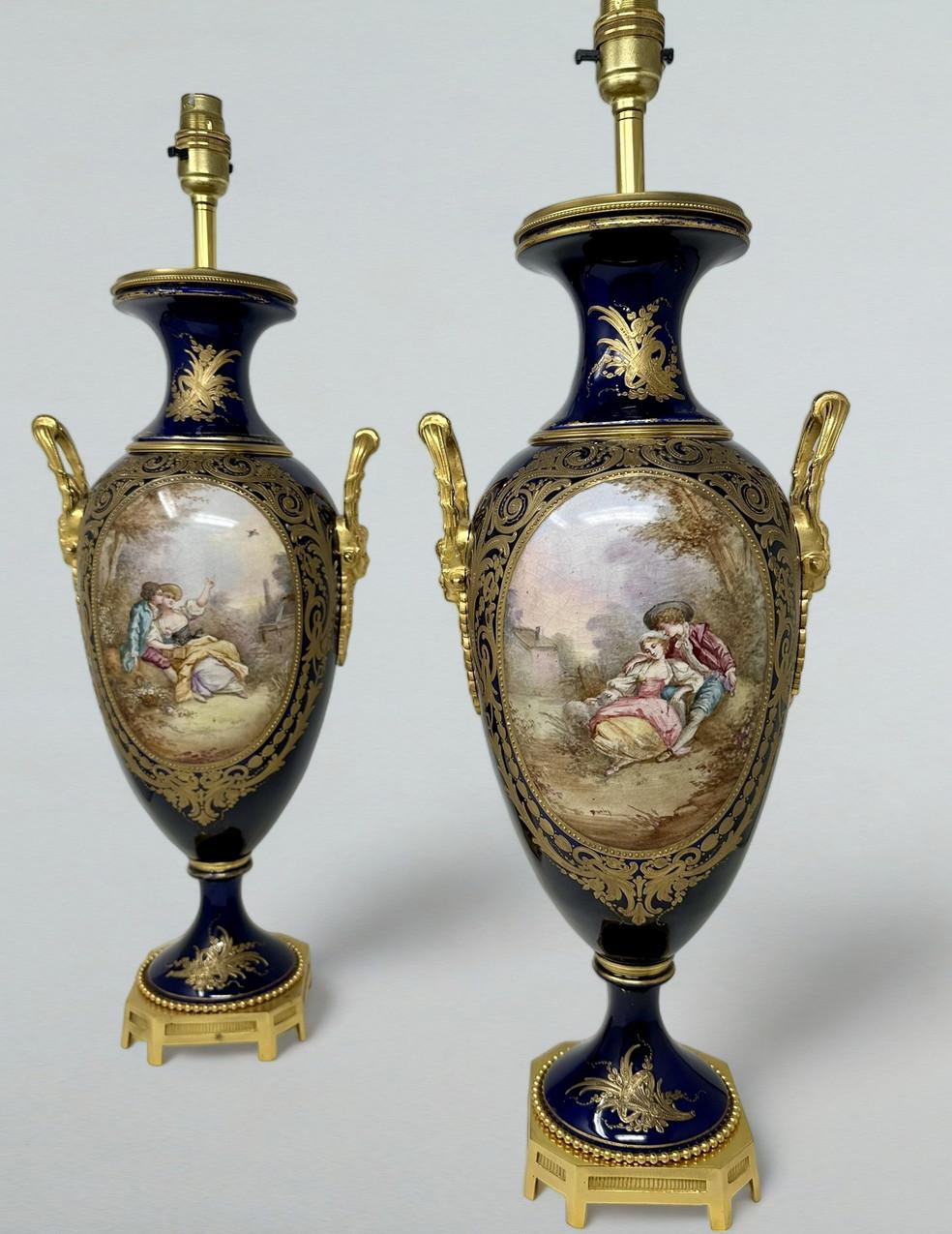 Stunning imposing Pair of French Sevres Soft Paste Porcelain and Ormolu Twin Handle Electric Table Lamps of traditional bulbous form, and of good size proportions, raised on a very ornate dome shaped circular porcelain base on a plain square support