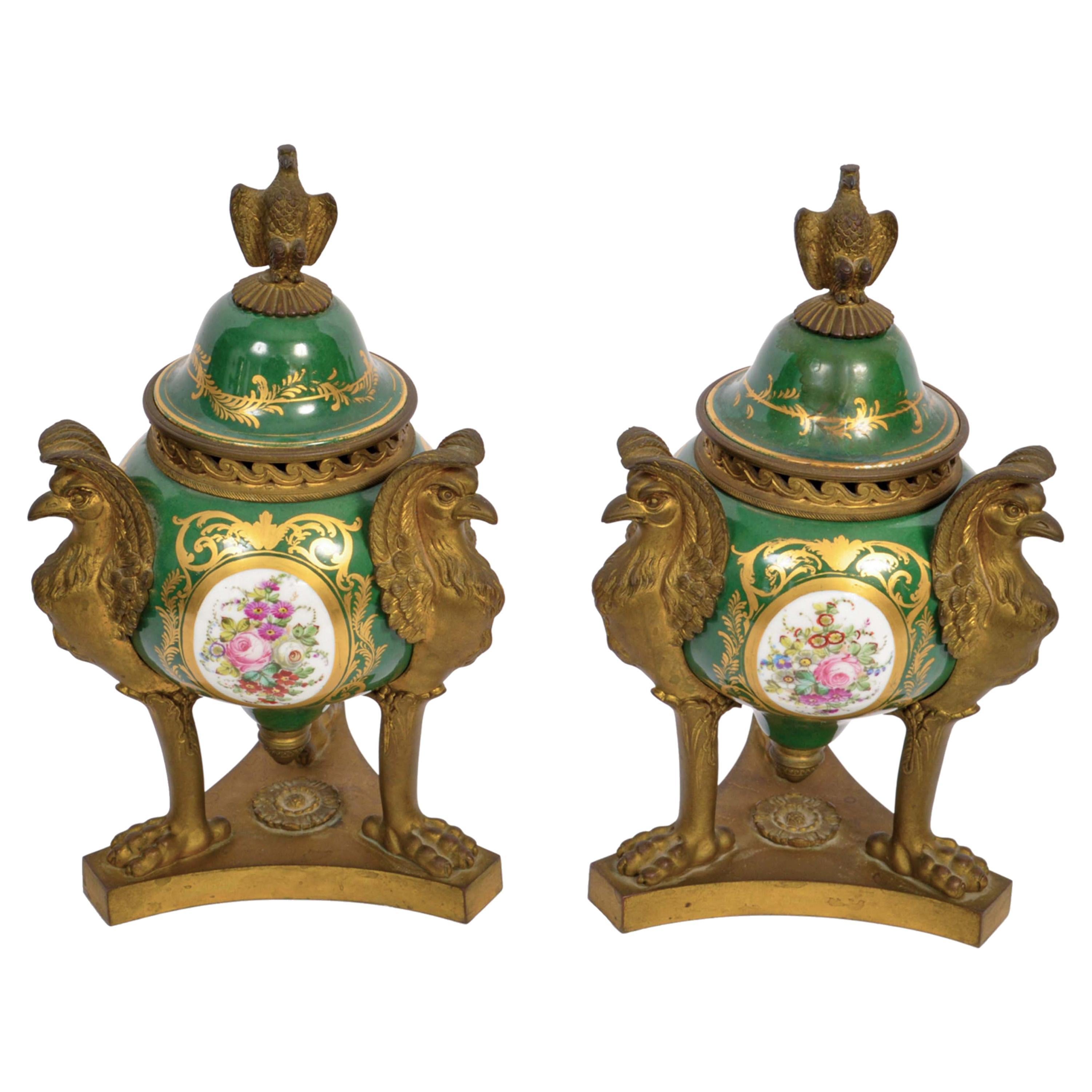 Pair of Antique French 'Sevres' porcelain lidded pot pourri and gilded bronze lidded urns, 1804-1809.
The urns having a rich red ground with gilded panels, the domed lids with gilded bronze eagle finials, below are gilt bronze 'wave' pattern air