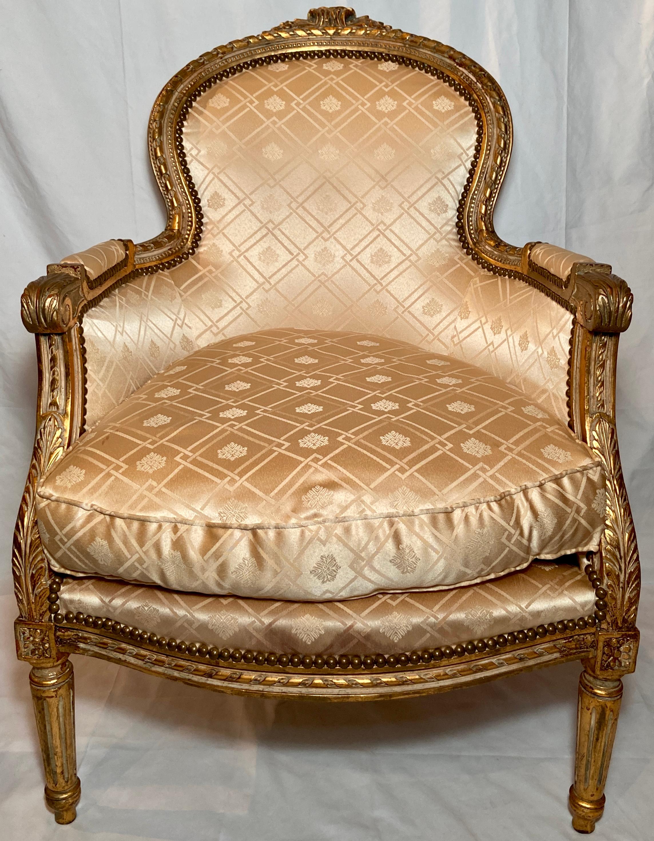 Pair antique French cream-colored silk upholstered carved giltwood arm-chairs, Circa 1890-1910.