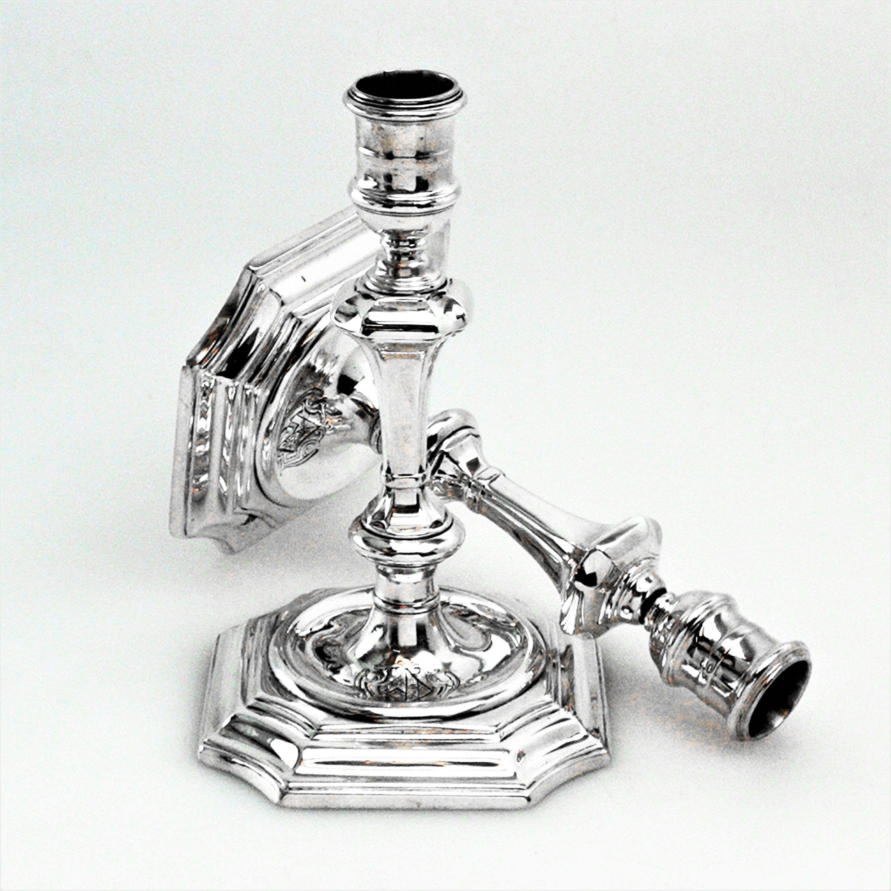 A pair of classic George I Antique sterling Silver Candlesticks standing on shaped stepped square based with a sunken well in the centre. Each Candlestick has a shaped knopped column and elegant capitals. Each Candlestick has an engraved crest