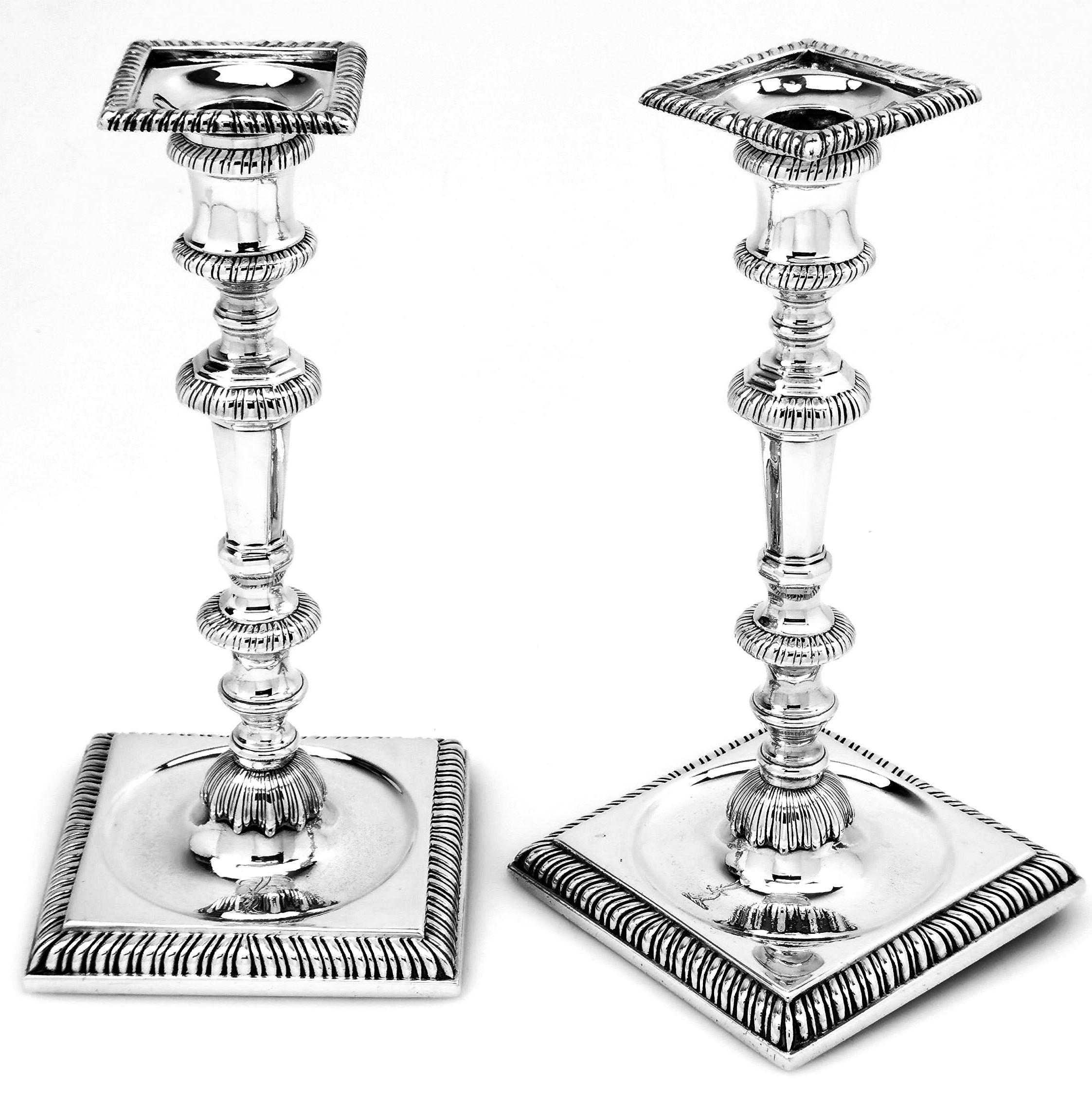 An impressive pair of Classic Antique George II solid Silver Candlesticks. These Georgian cast Silver Candlesticks have square bases with sunken wells and knopped columns with removable square silver sconces. The edges of the bases, knopped columns