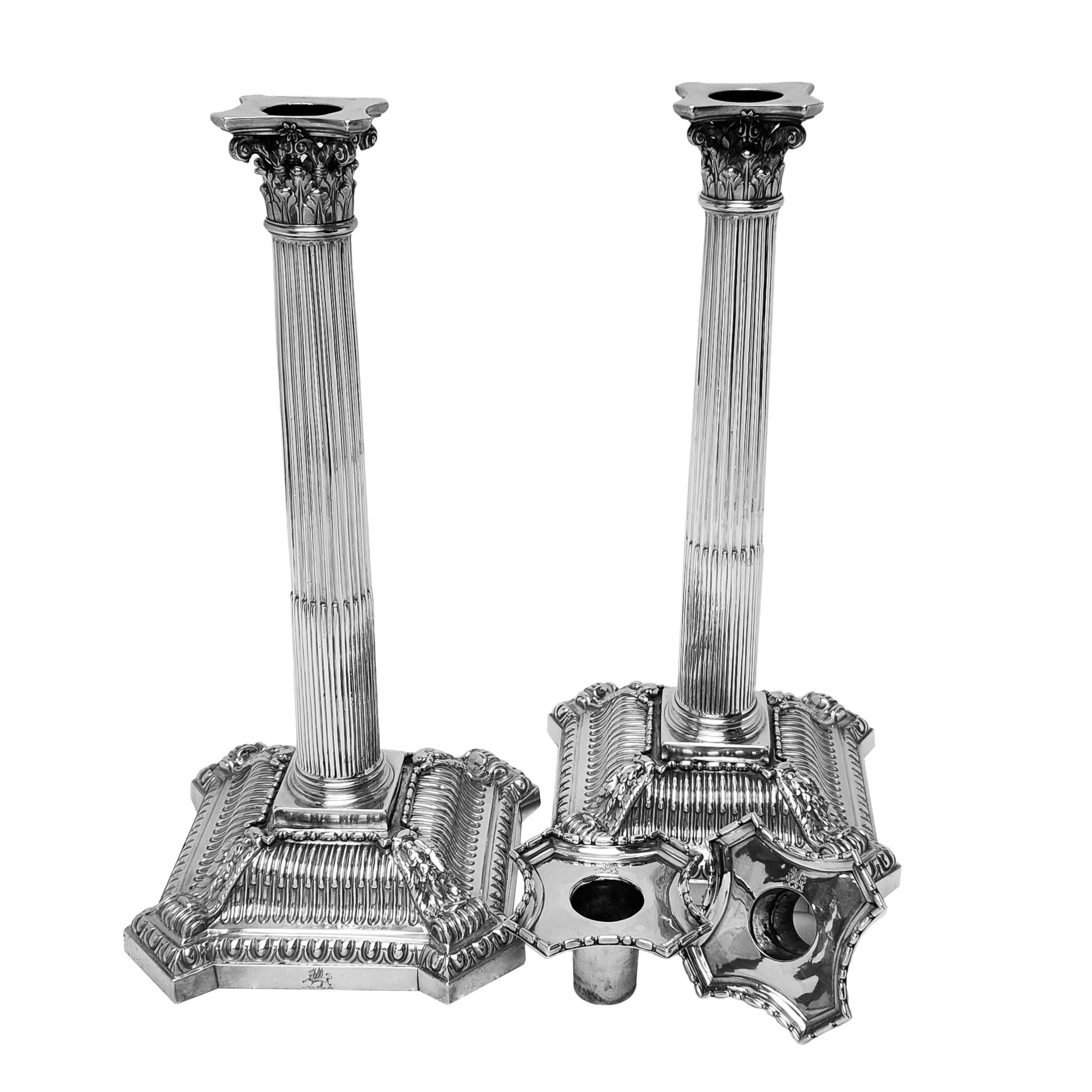 A magnificent Pair Antique Georgian Silver Candlesticks. This impressive pair of George II Candlesticks has a classic Corinthian style sconce on top of a fluted column. The Candlesticks have shaped square bases covered with detailed chased designs.