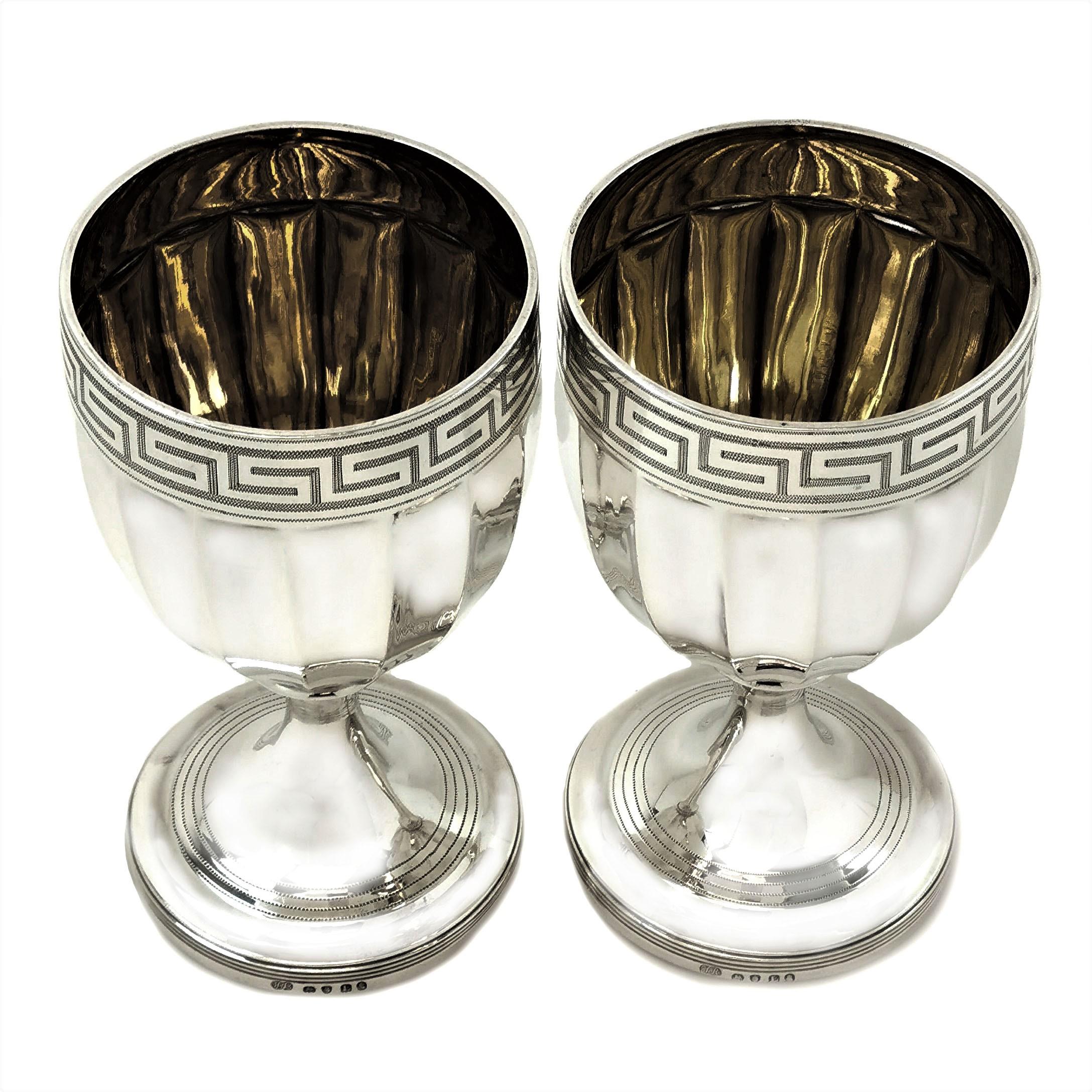 A pair of elegant antique Georgian solid silver goblets with a classic Greek Key pattern border below the rim and a panelled body. The foot of the goblet has a subtle reeded pattern. These Goblets are of substantial size.

Made in London in 1806