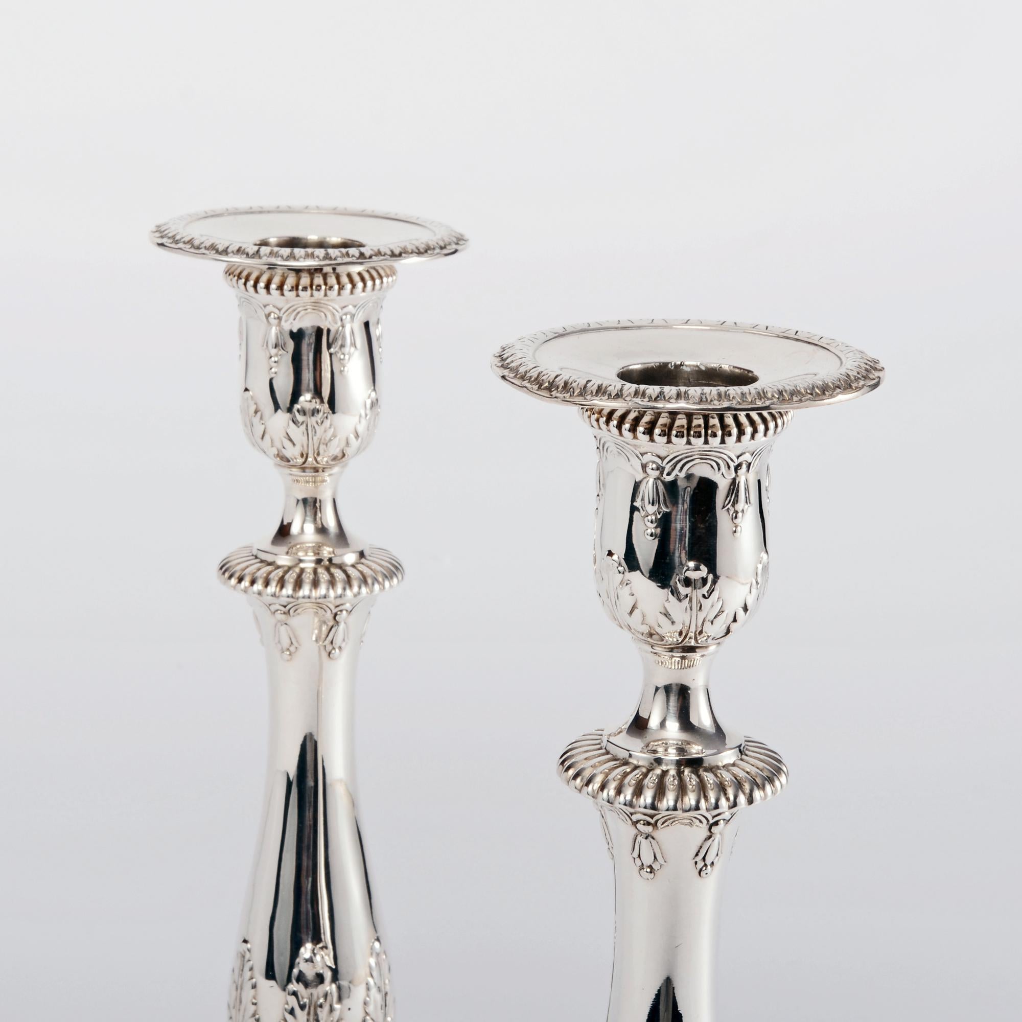 Fine pair of Edwardian silver candlesticks in the Georgian style that was typical of the late 18th century. The square bases are decorated with acanthus leaves, while the spreading fluted stems taper elegantly and also feature fluted and acanthus