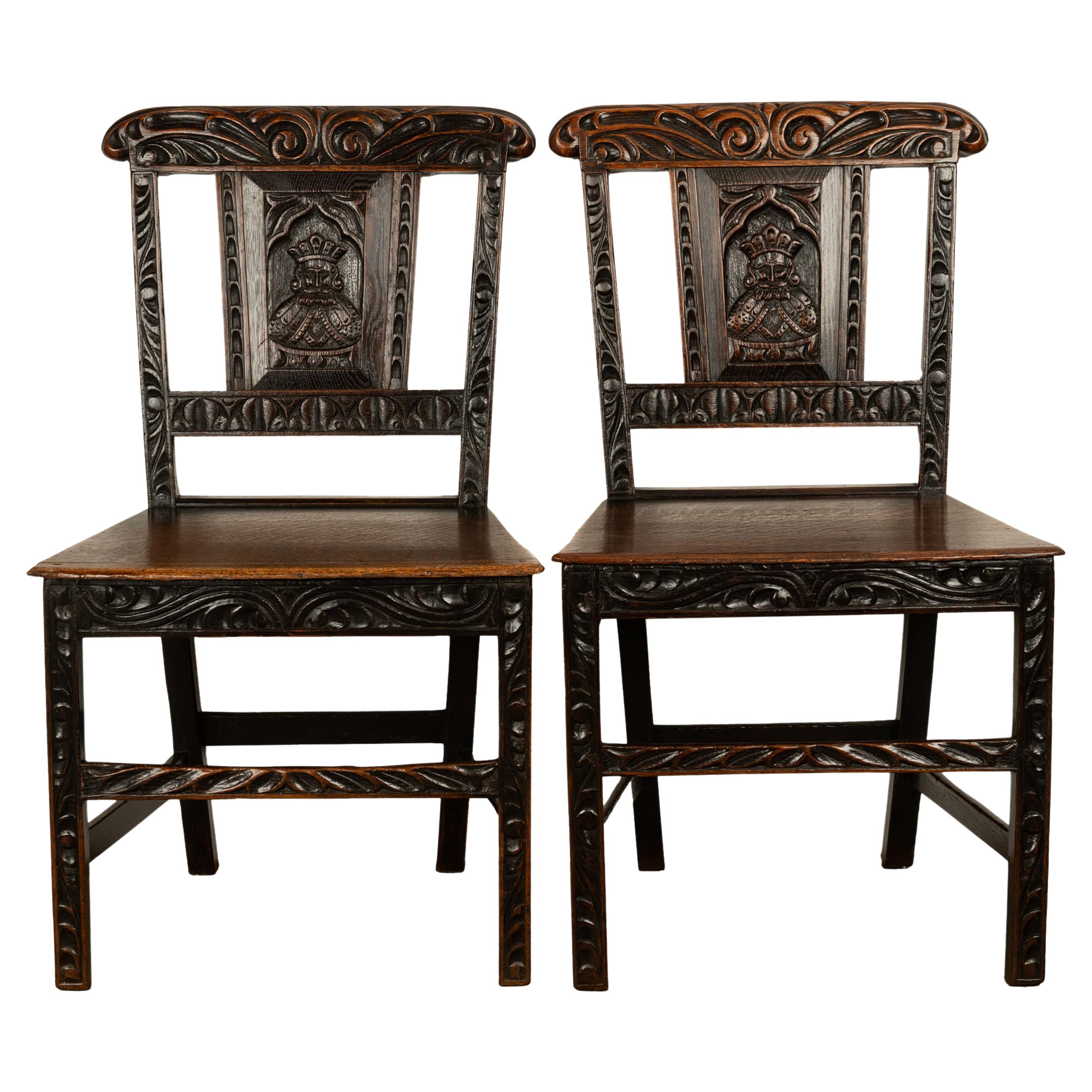 A rare and unusual pair of antique country Georgian carved oak side chairs, circa 1760.
The chairs are from the reign of king George III and they are carved in the Medieval Revival style, the back rests & back splats are deeply carved. To the center