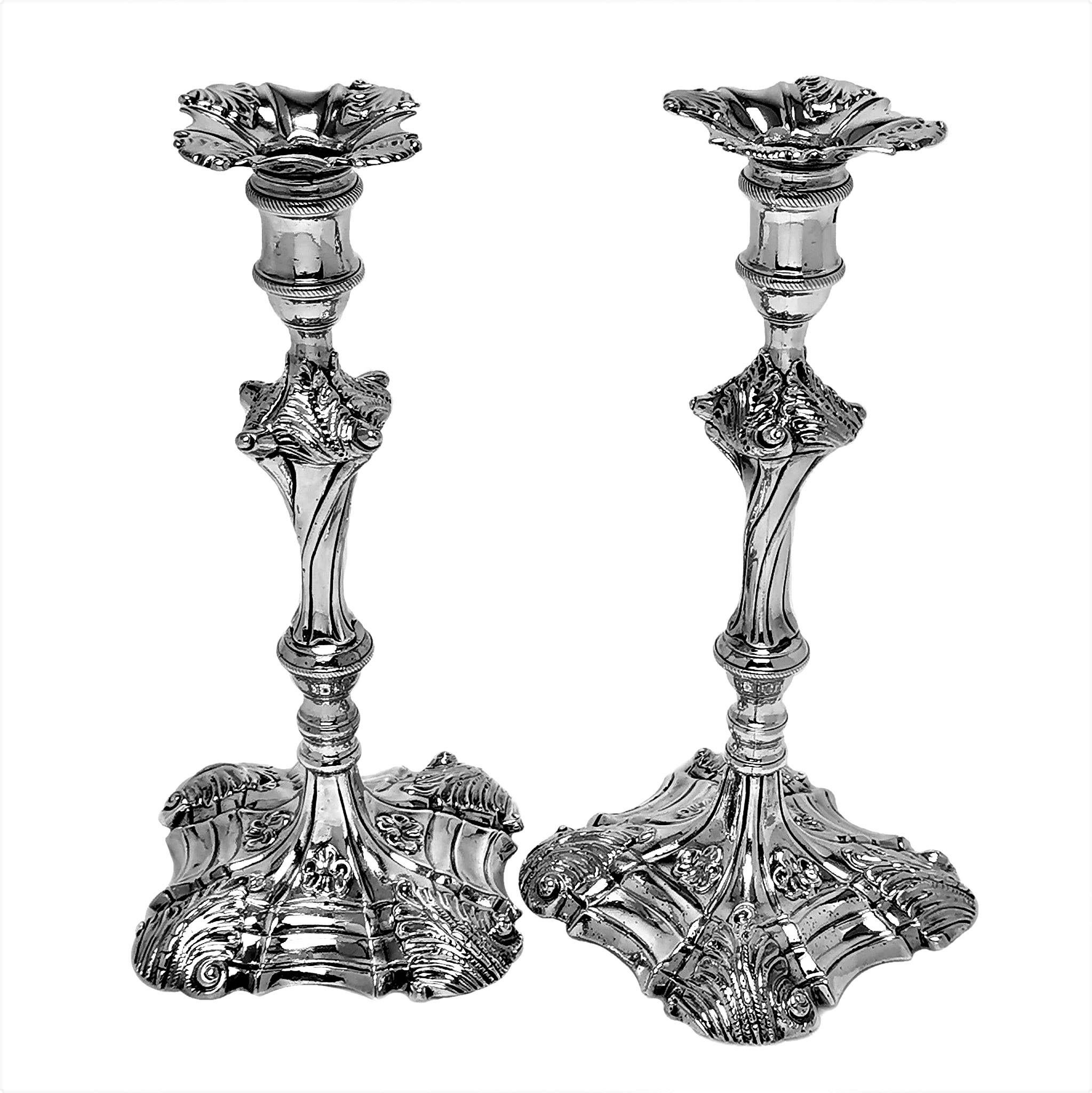 A pair of impressive Antique George III solid Silver Candlesticks with elegant Rococo style scroll and leaf patterns on the shaped square base and the knopped columns. The Candlesticks have removable patterned sconces. 

Made in London in 1765 by