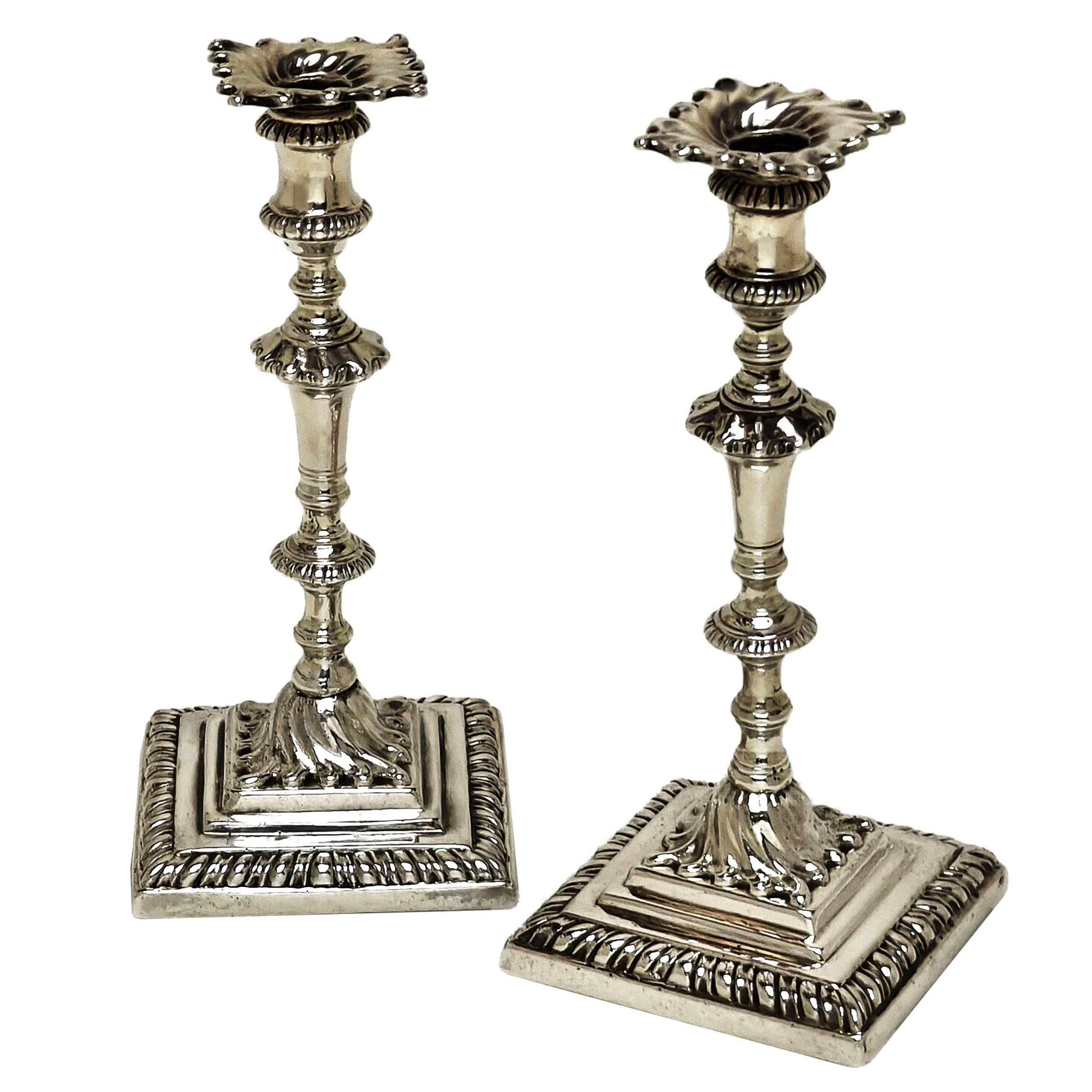 Une élégante paire de bougeoirs anciens en argent Sterling George III avec des bases carrées. Ces chandeliers géorgiens sont dotés d'appliques cannelées amovibles et de colonnes ornées. Les bases ont un design en escalier avec un motif de cannelures
