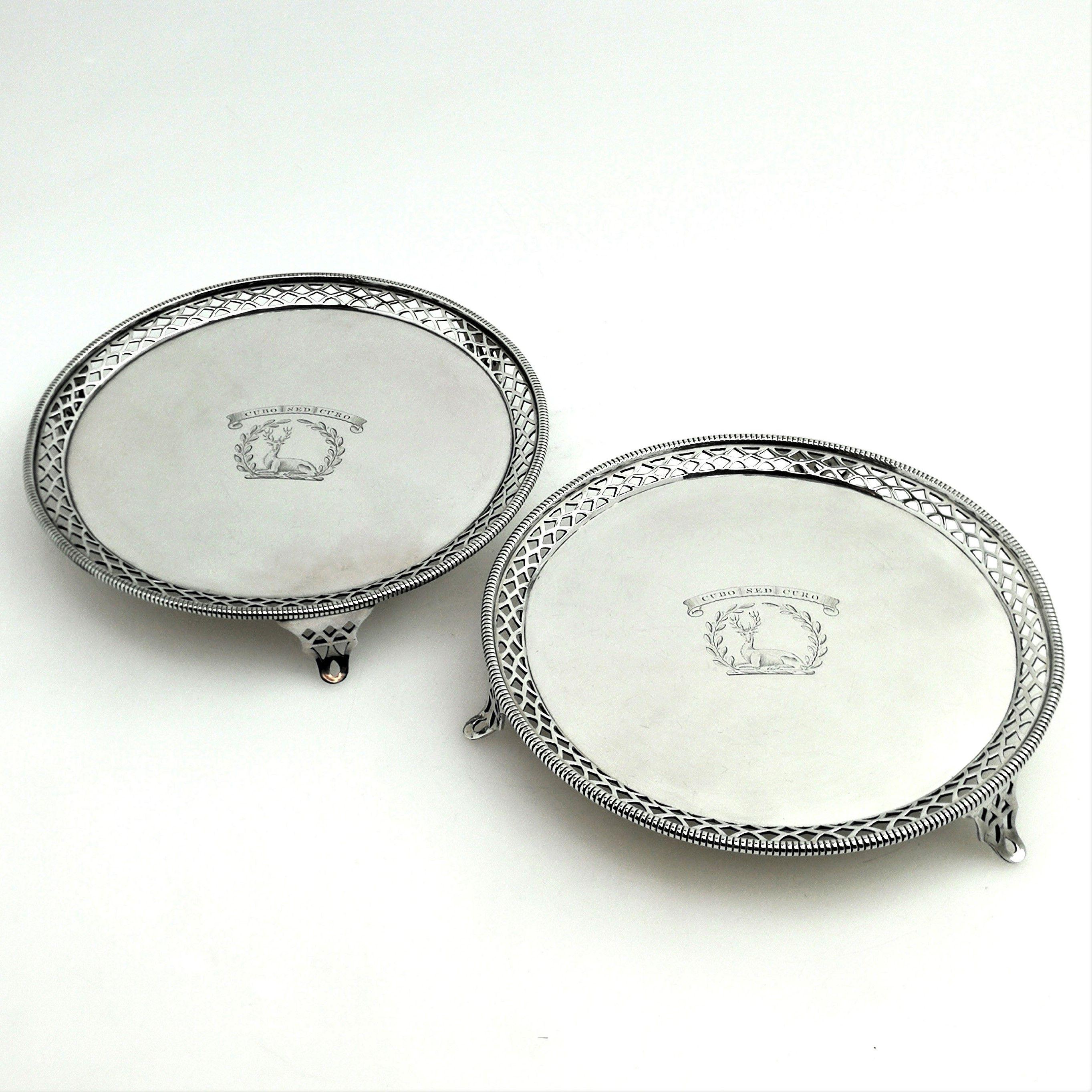 A pair of elegant George III Antique sterling Silver Salvers featuring a pierced border with a gadroon pattern rim. Each Tray has a crest engraved in the centre and each stands on 3 pierced feet.
 
 Made in London in 1768 by John Carter II.
 
