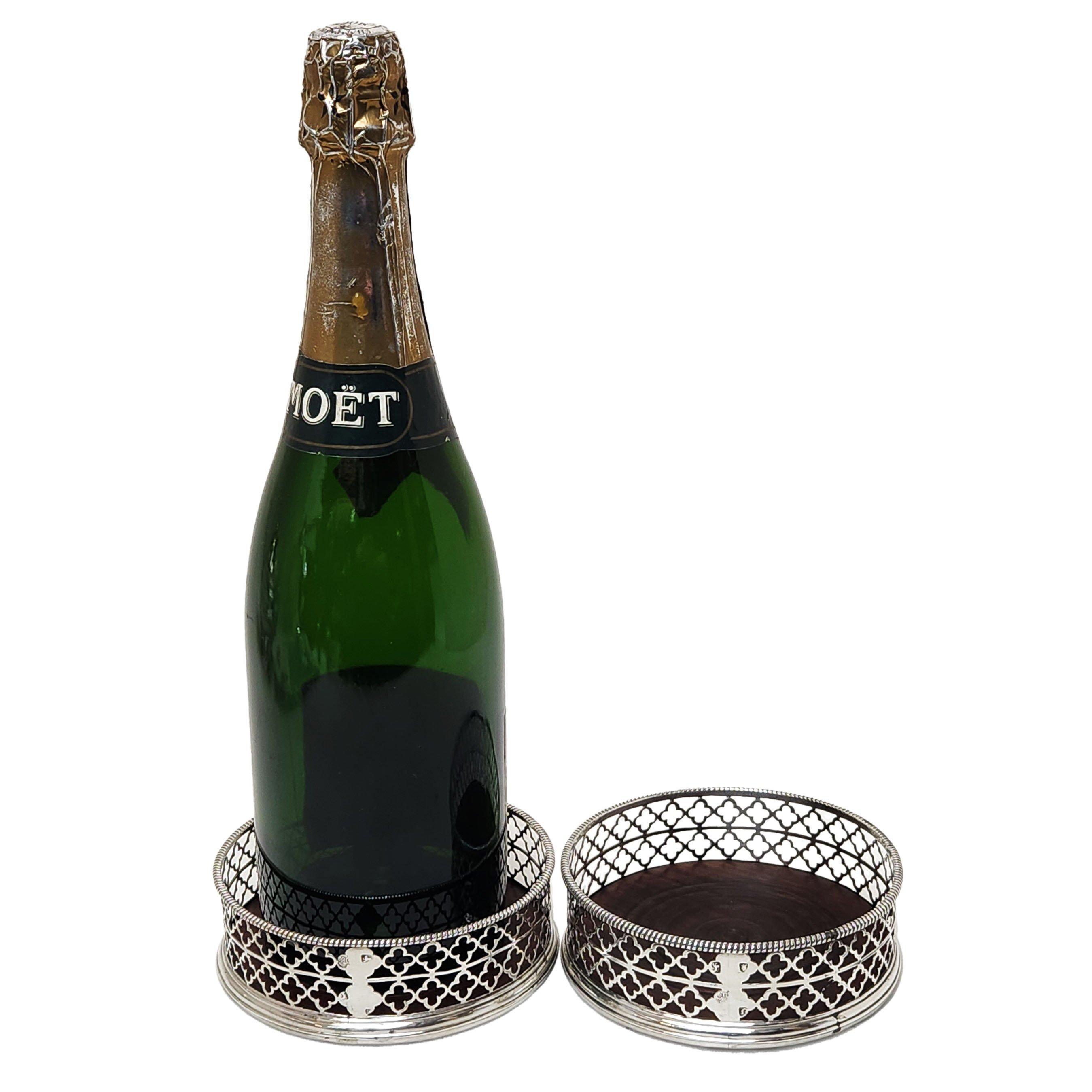 A lovely pair of Antique George III Silver Wine Bottle Coasters with an elegant pierced quatrefoil design on the sides of the coasters. The bases of the coasters are made of turned wood.

Made in London in 1768 by Thomas Whipham.
 
Approx. Diameter