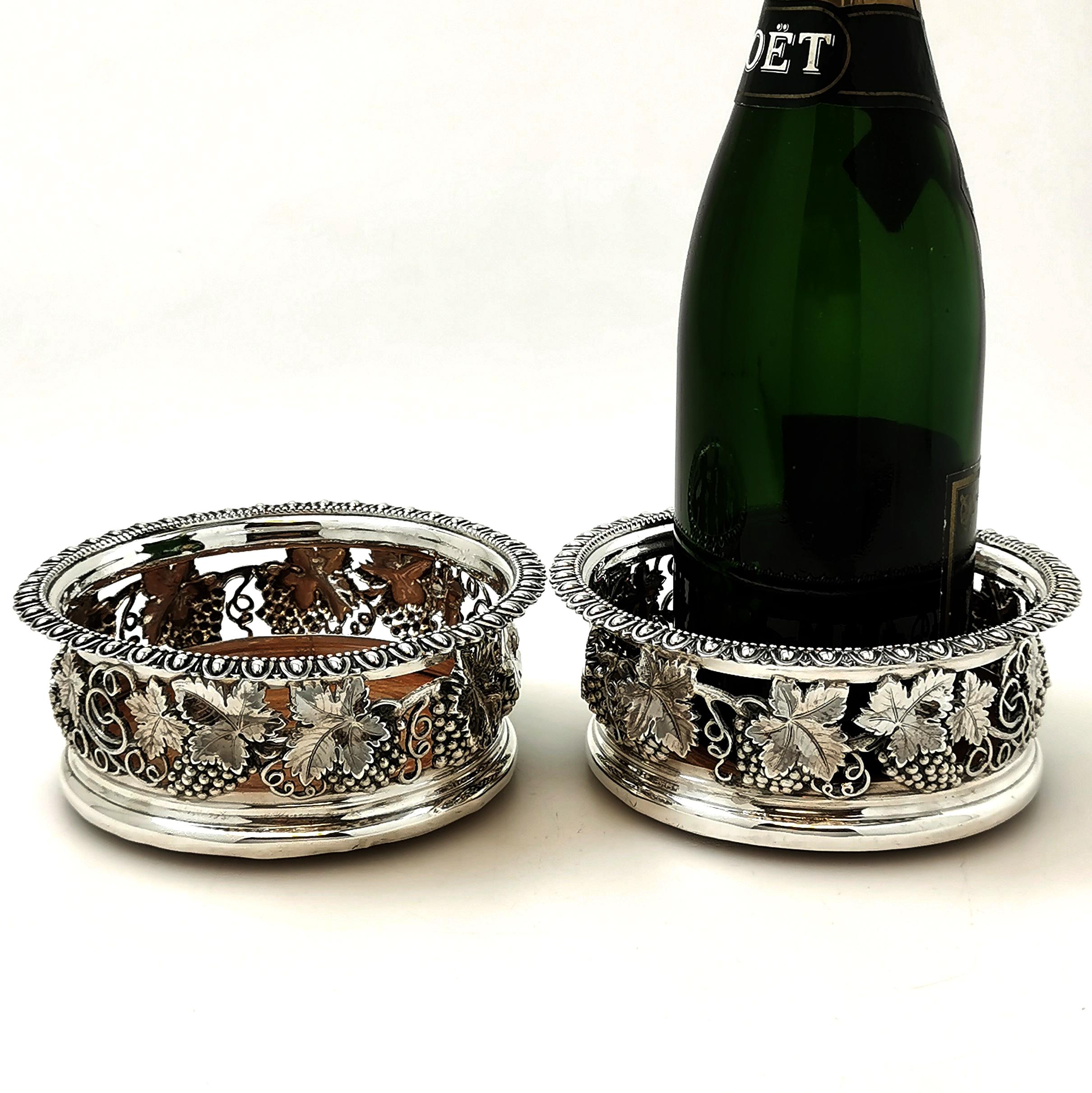 A pair of magnificent Antique George IV Sterling Silver Wine Bottle Coasters with an impressive chased and pierced grape vine and leaf design. The Coasters have a wooden base with a plain Silver central button.

Made in Sheffield in 1821 by Smith,