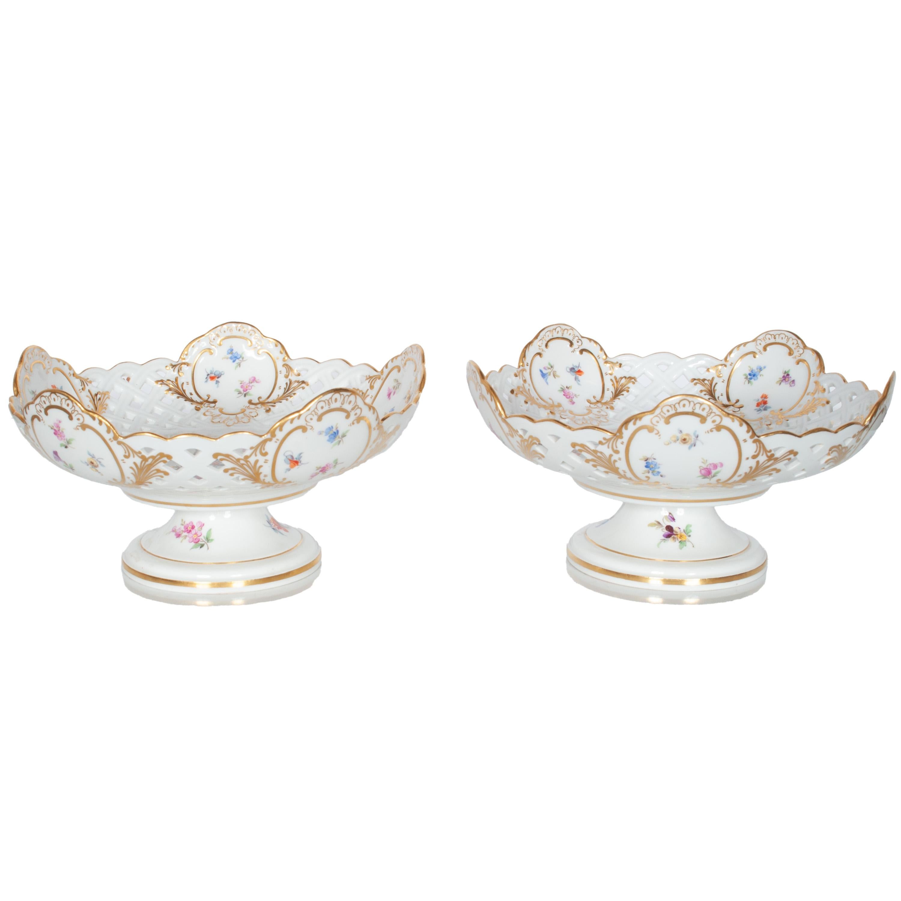 A very good pair of antique mid 19th century Meissen porcelain compotes or footed bowls, circa 1850.
The bowls are very finely made of open pierced work, with a band of diamond shaped cut out reticulations, these are punctuated with five ornate