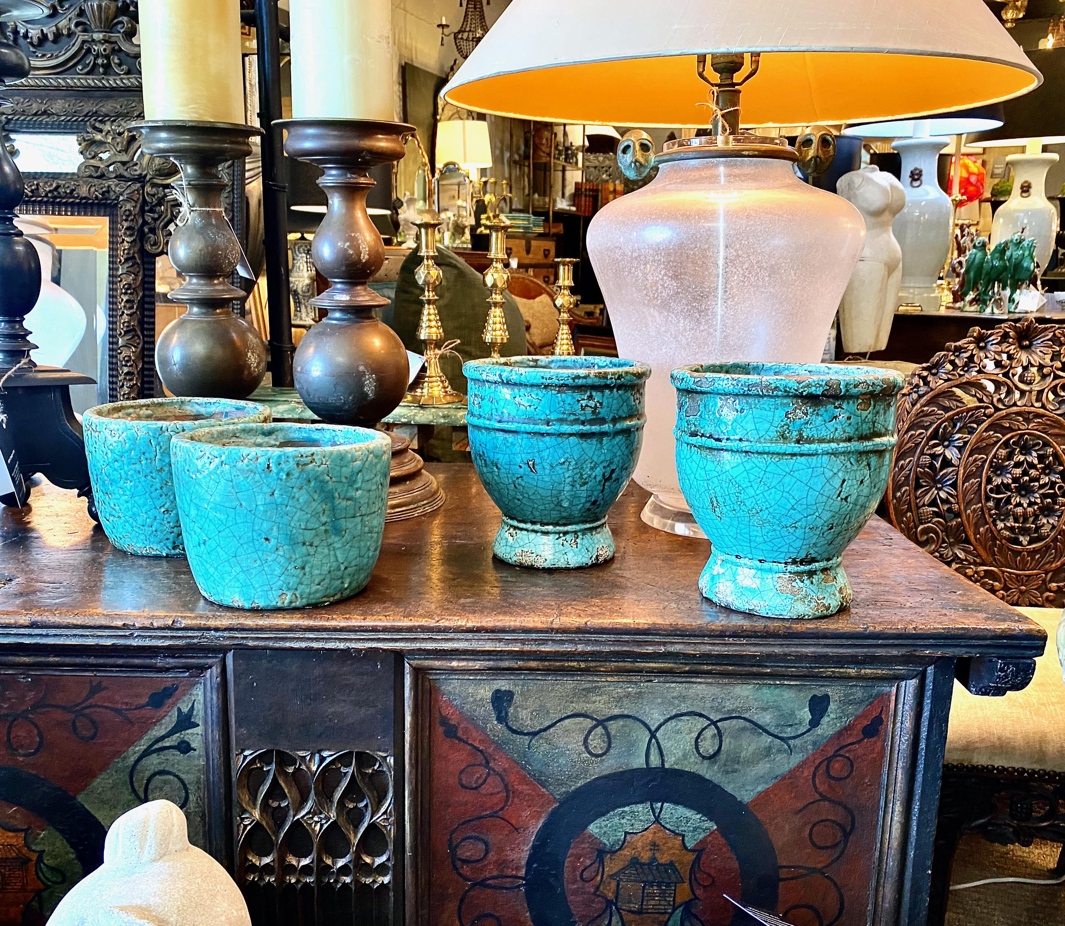 This a very decorative pair of antique turquoise glazed terracotta pots. The pots were acquired from a Michael Smith-designed estate and are striking in their bold color and intense crackle glaze. The size and striking coloration make these the