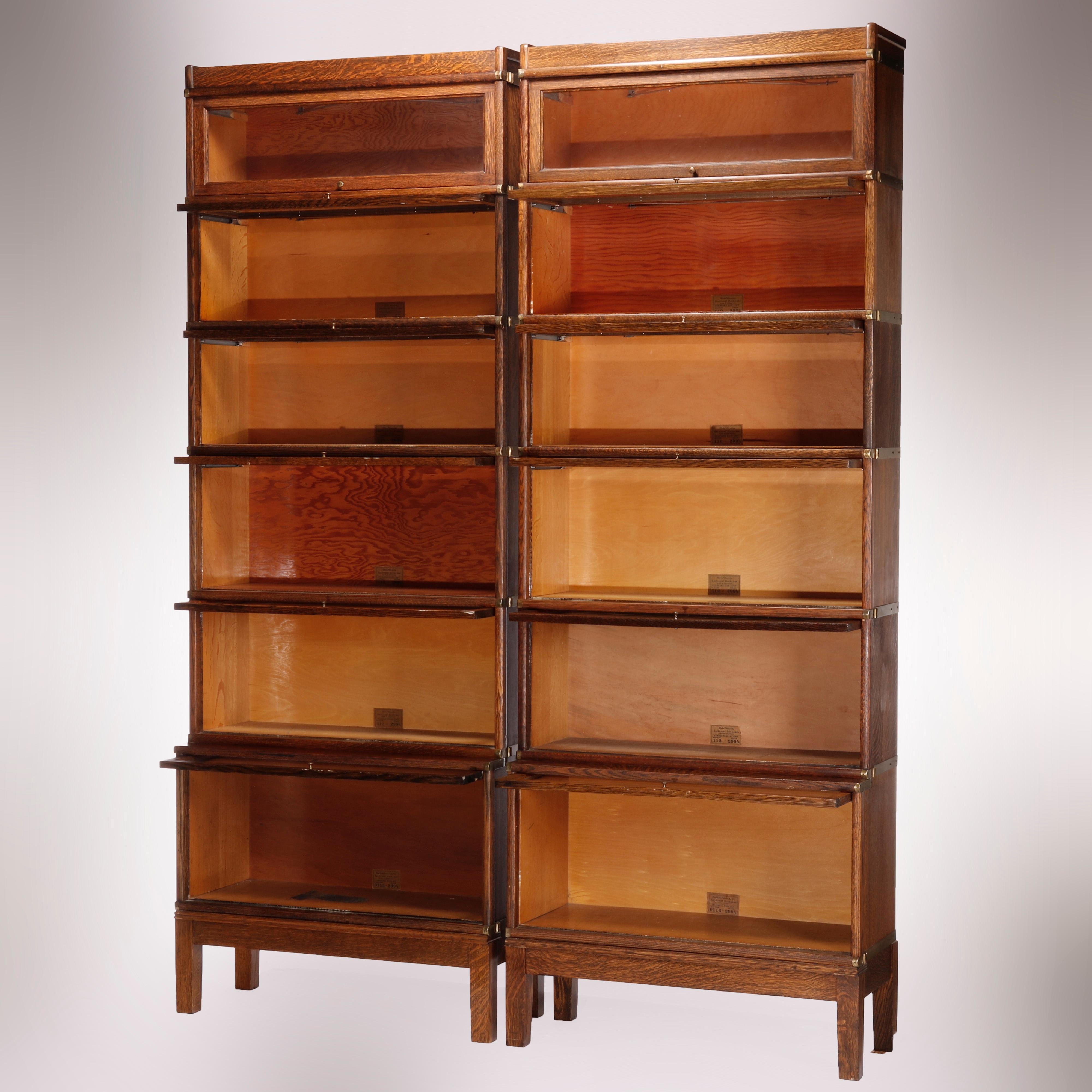 An antique pair of matching sectional barrister bookcases by Globe Wernicke offers quarter sawn oak construction, each with six stacks having pull out glass doors and raised on square and straight legs, maker labels as photographed,