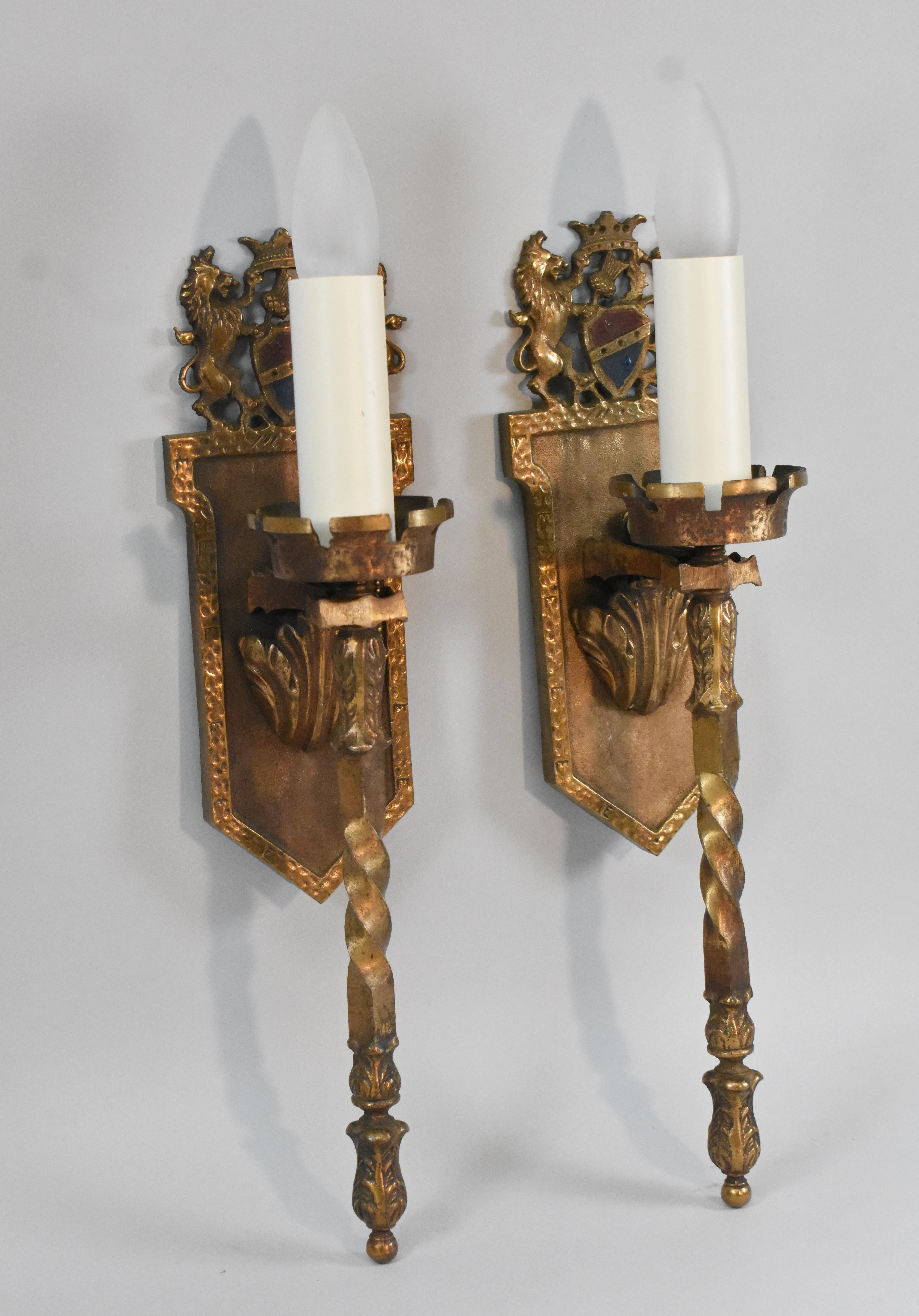 Pair of brass Gothic wall sconces with center top shield with thistle and flanking unicorns. Twisted stem design. Fixtures have been rewired.