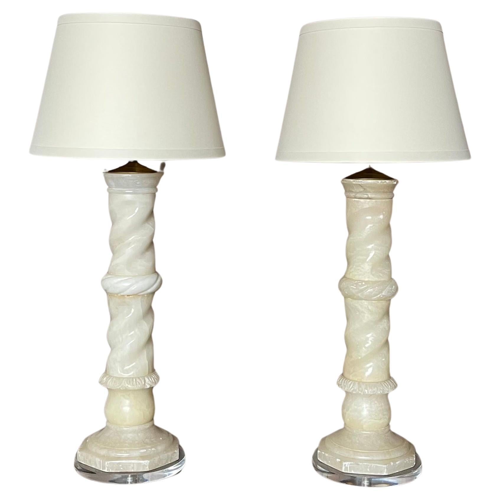 Elevate your space with this exquisite pair of Italian antique alabaster lamps, transformed into stunning pieces of functional art. Resting on sleek lucite bases, these lamps exude elegance and sophistication. Adorned with new Gold lined Tanner