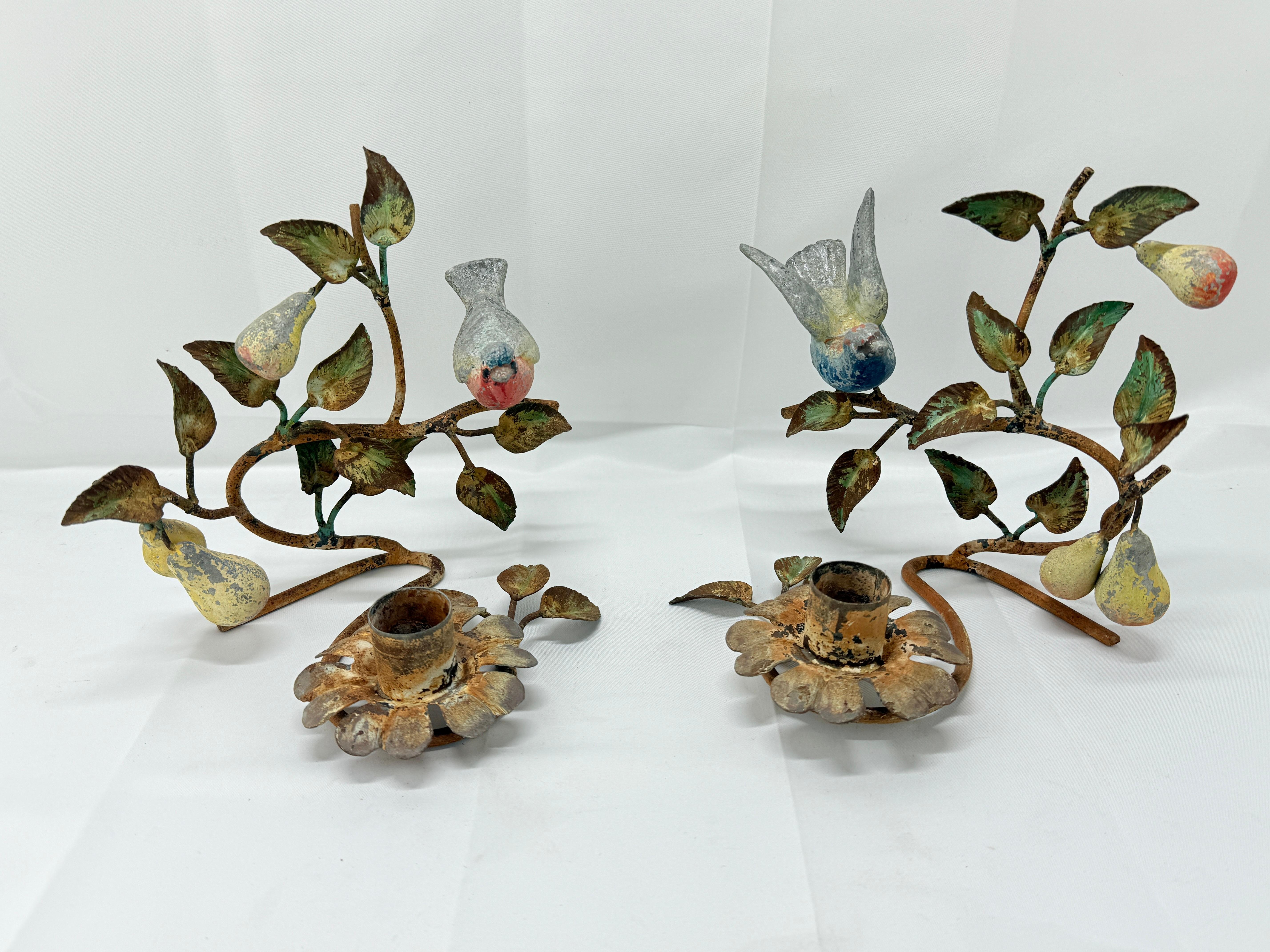 This exquisite pair of antique Italian tole candle holders showcases the elegance and craftsmanship synonymous with Italian decorative arts. Each candle holder features a charming bird and foliate motif, intricately hand-painted and crafted from