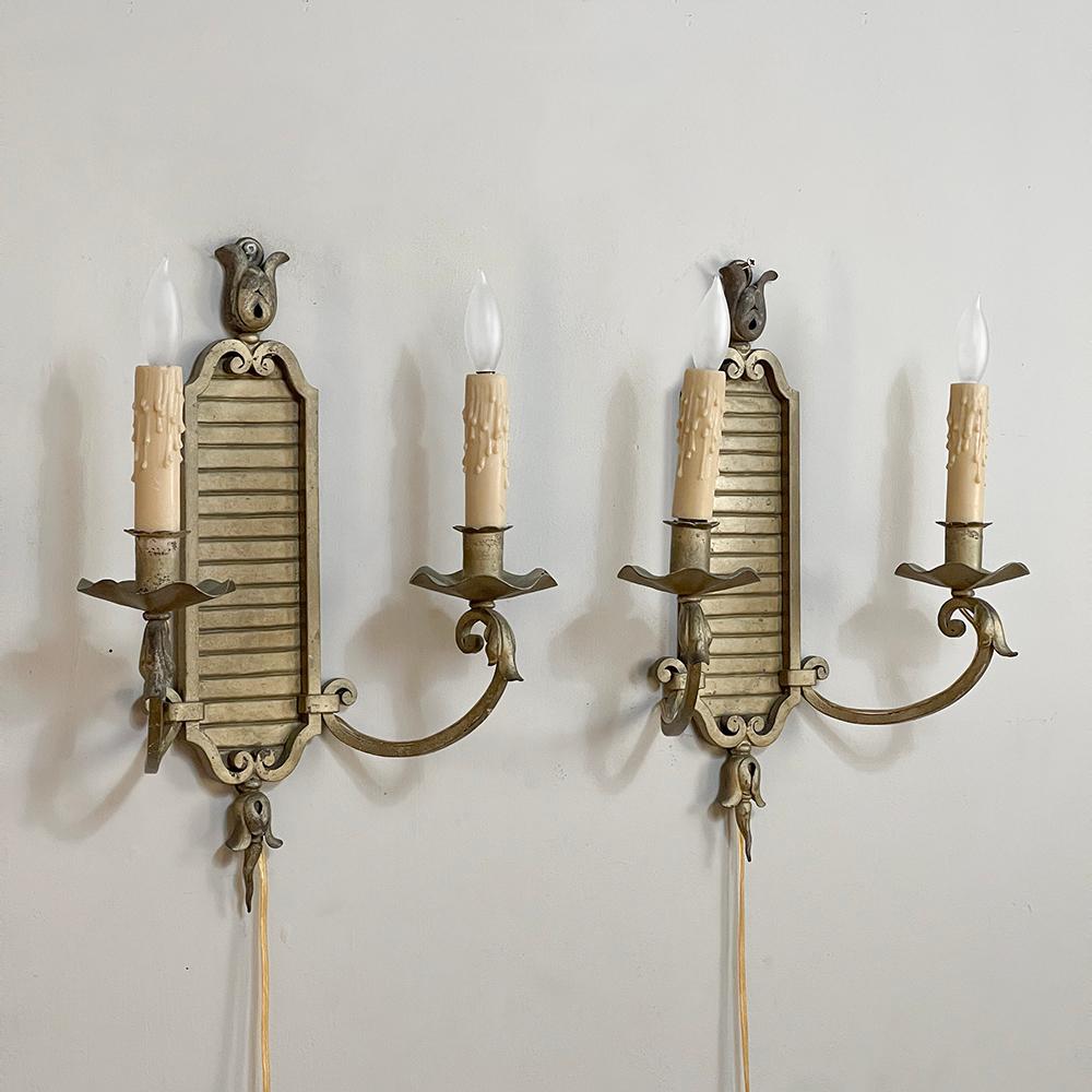 Pair Italian Antique Bronze Neoclassical Electrified Wall Sconces feature a tailored design that presents a less formal look, yet still provides an understated elegance that will work wonders for illuminating any room!  The framed plaque backdrop